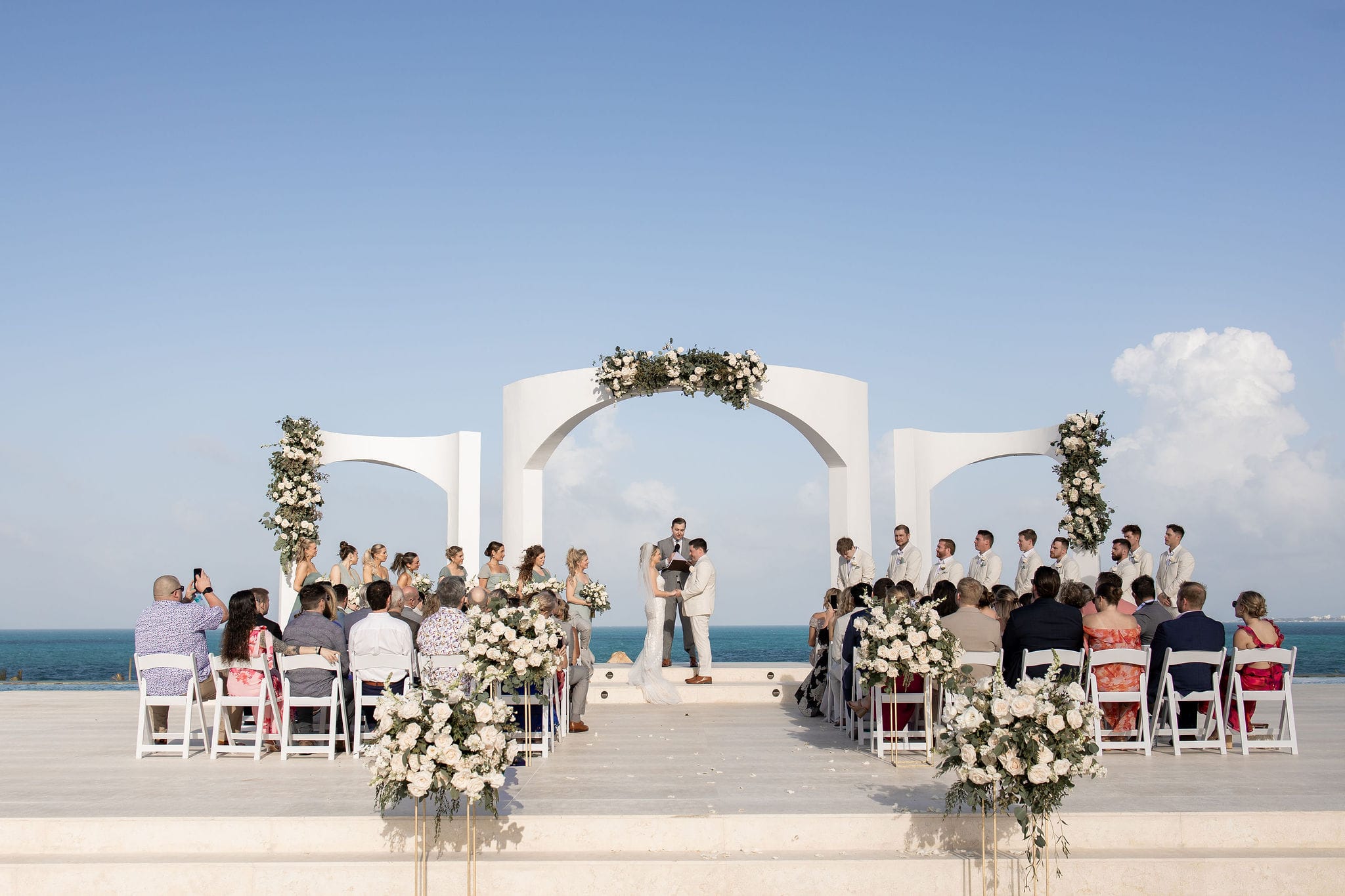 Lauren and Ben's destination wedding by the ocean, featuring their bridal party and seated guests.
