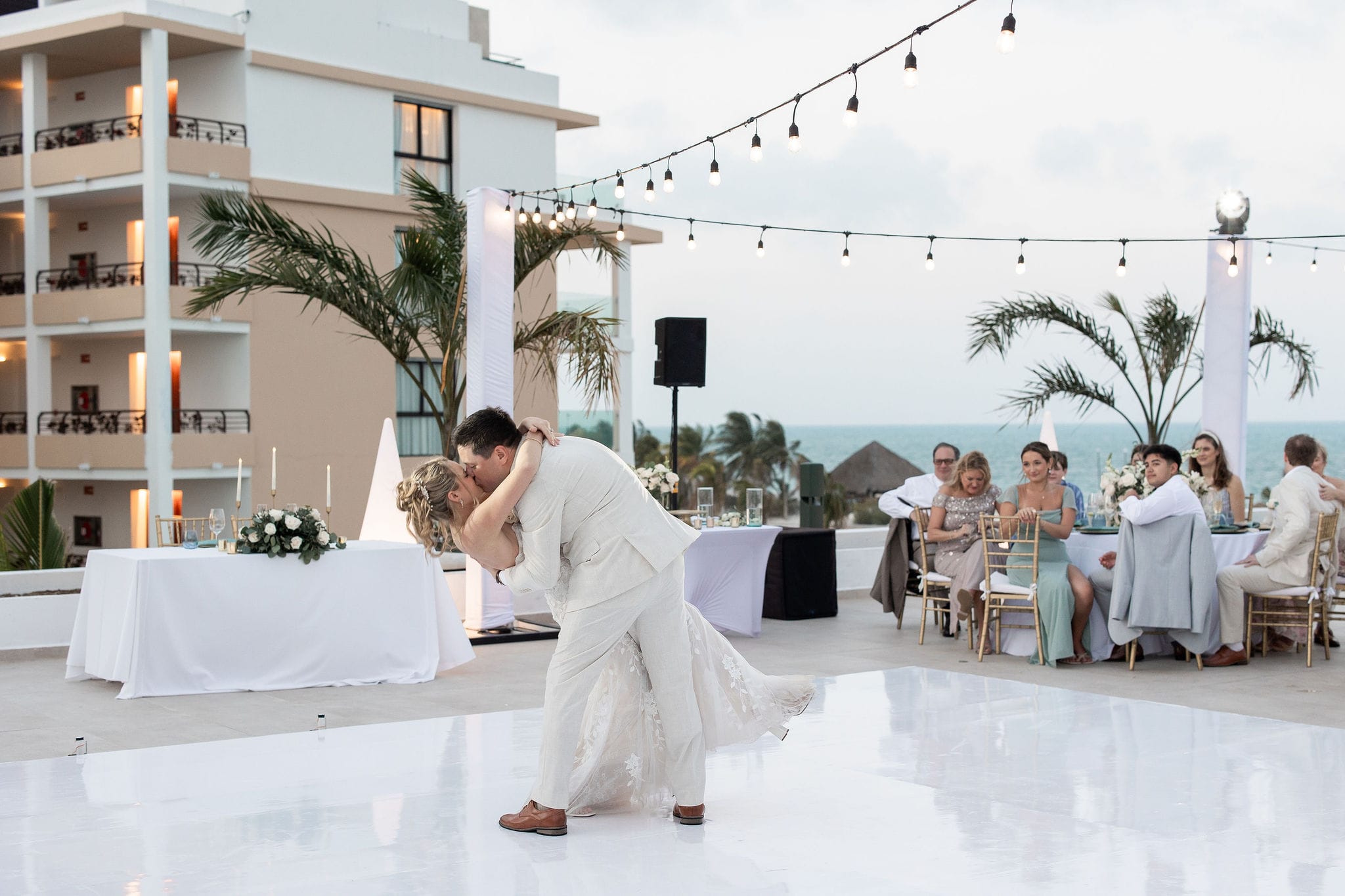 Lauren and Ben share a dip as they dance together during their destination wedding reception outdoors.