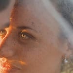 Close-up of a couple at their destination wedding, sunlight illuminating the bride&rsquo;s face and veil.