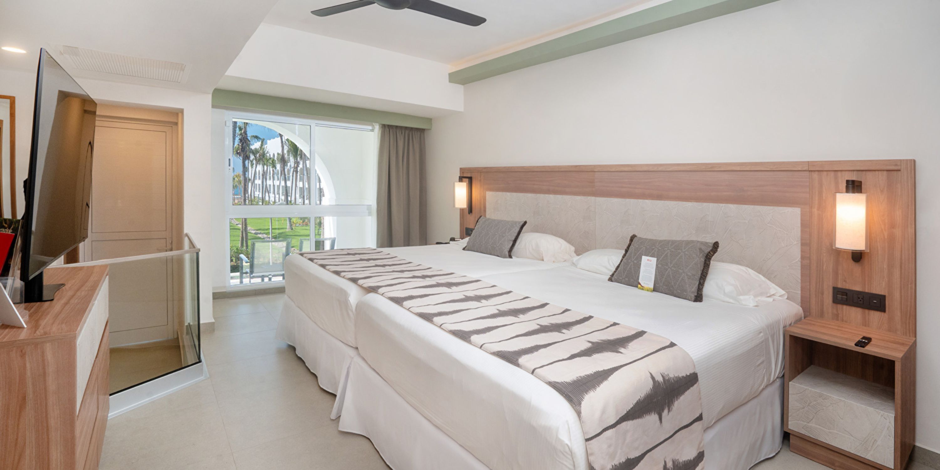 Hotel Riu Jalisco room with 2 large beds, TV, window, and modern decor&mdash;ideal for a destination wedding.