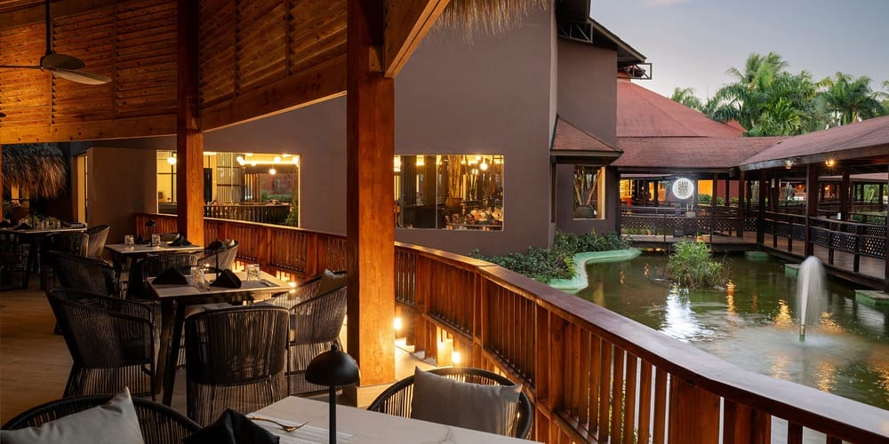 Outdoor restaurant seating with views of a pond and fountain, perfect for a destination wedding evening.