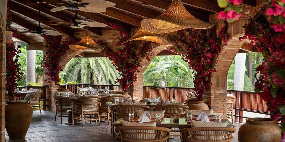Charming outdoor restaurant with brick arches and pink flowers, perfect for a destination wedding setting.