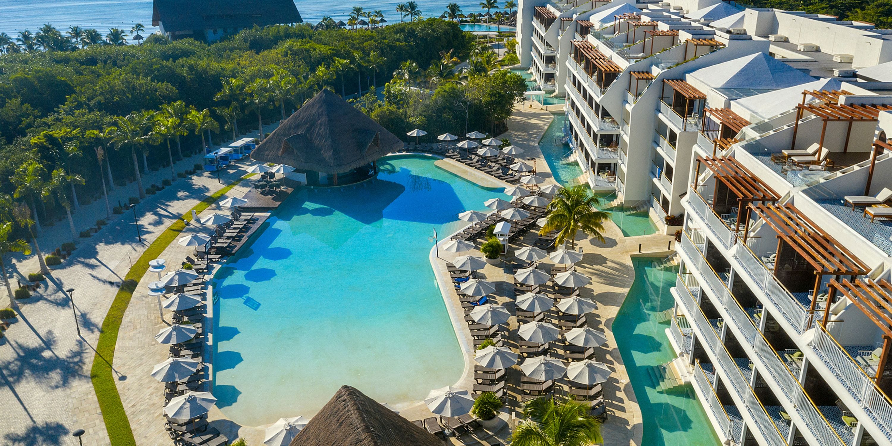 Aerial view of Ocean Riviera Paradise&rsquo;s pool, perfect for a destination wedding, with lounge chairs and palms.
