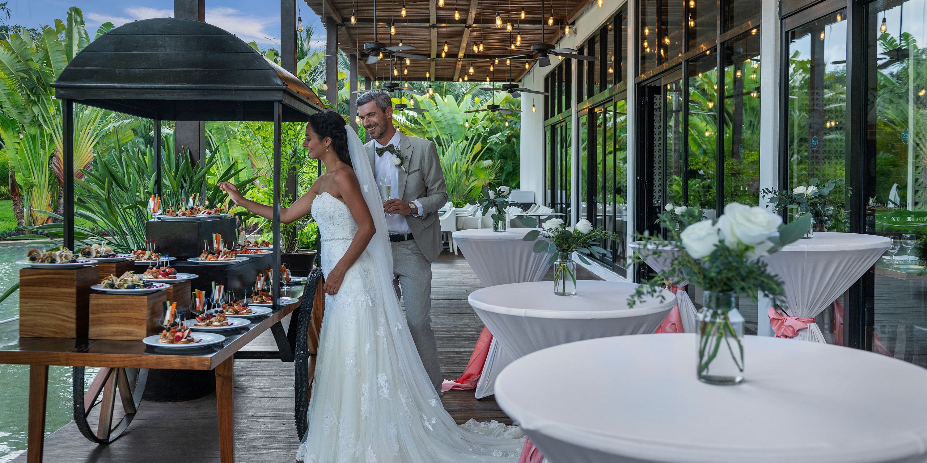 The bride and groom savor a buffet at their Ocean Riviera Paradise destination wedding outdoors.