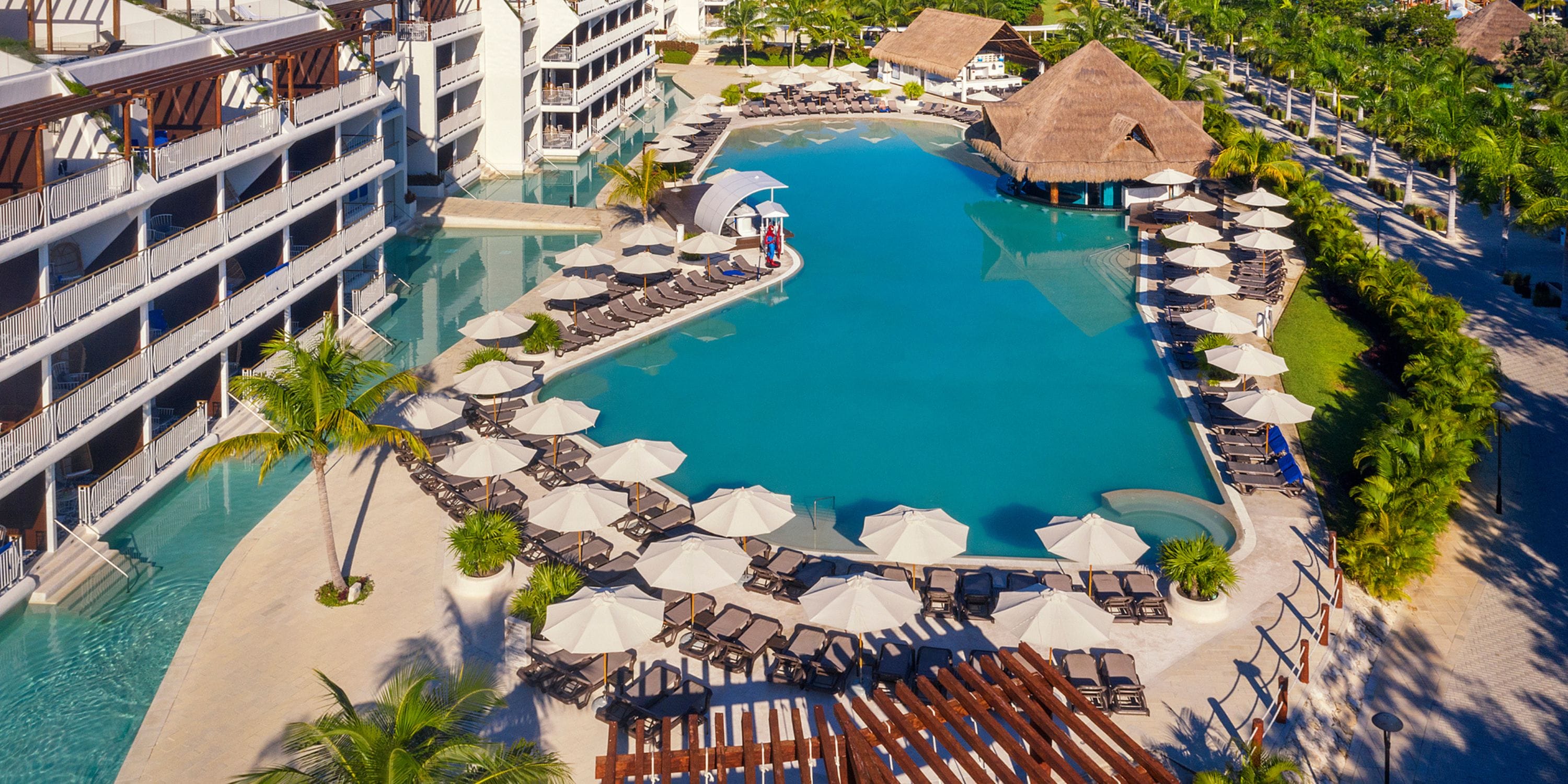 Aerial view of Ocean Riviera Paradise&rsquo;s pool, perfect for a destination wedding, with chairs and palm trees.