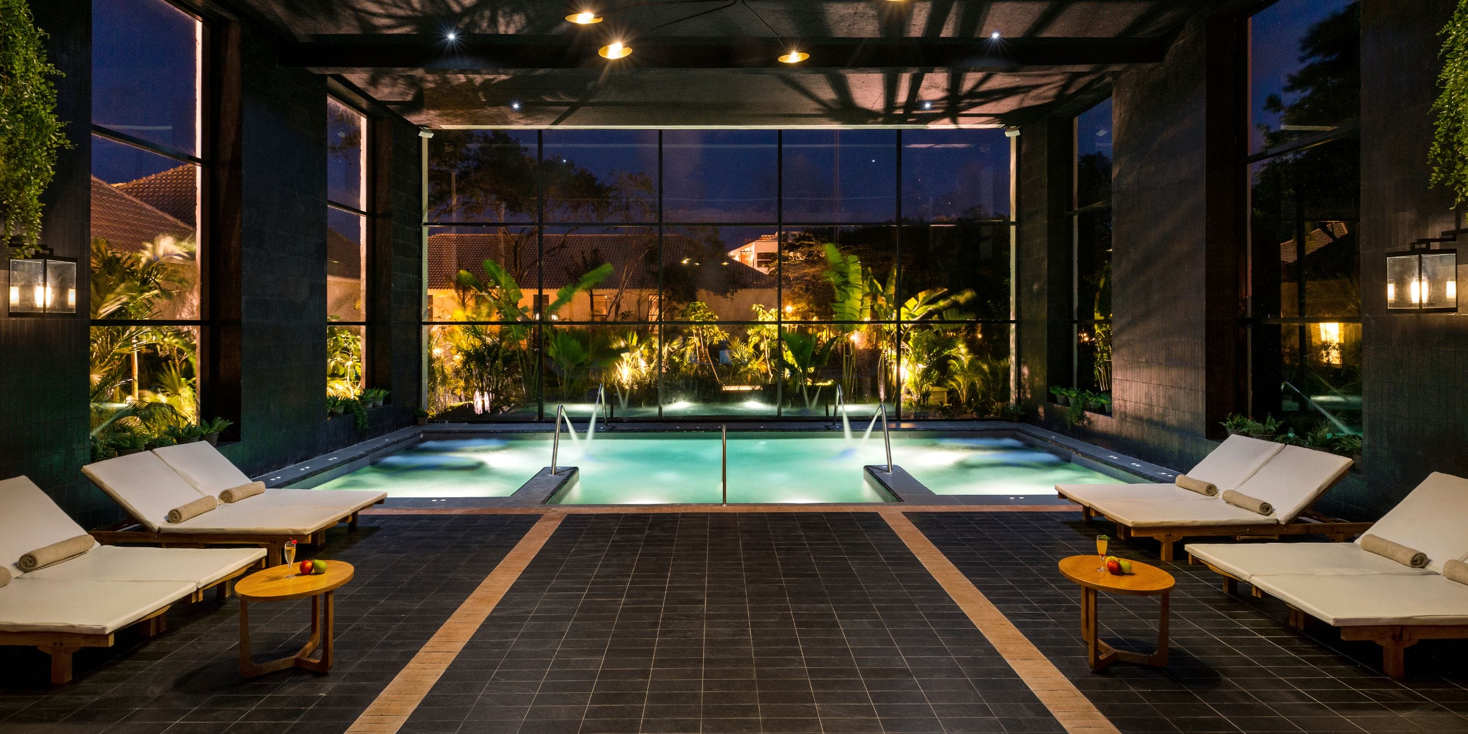 Ocean Riviera Paradise: Indoor pool at night, perfect for destination weddings, with lounge chairs and garden views.