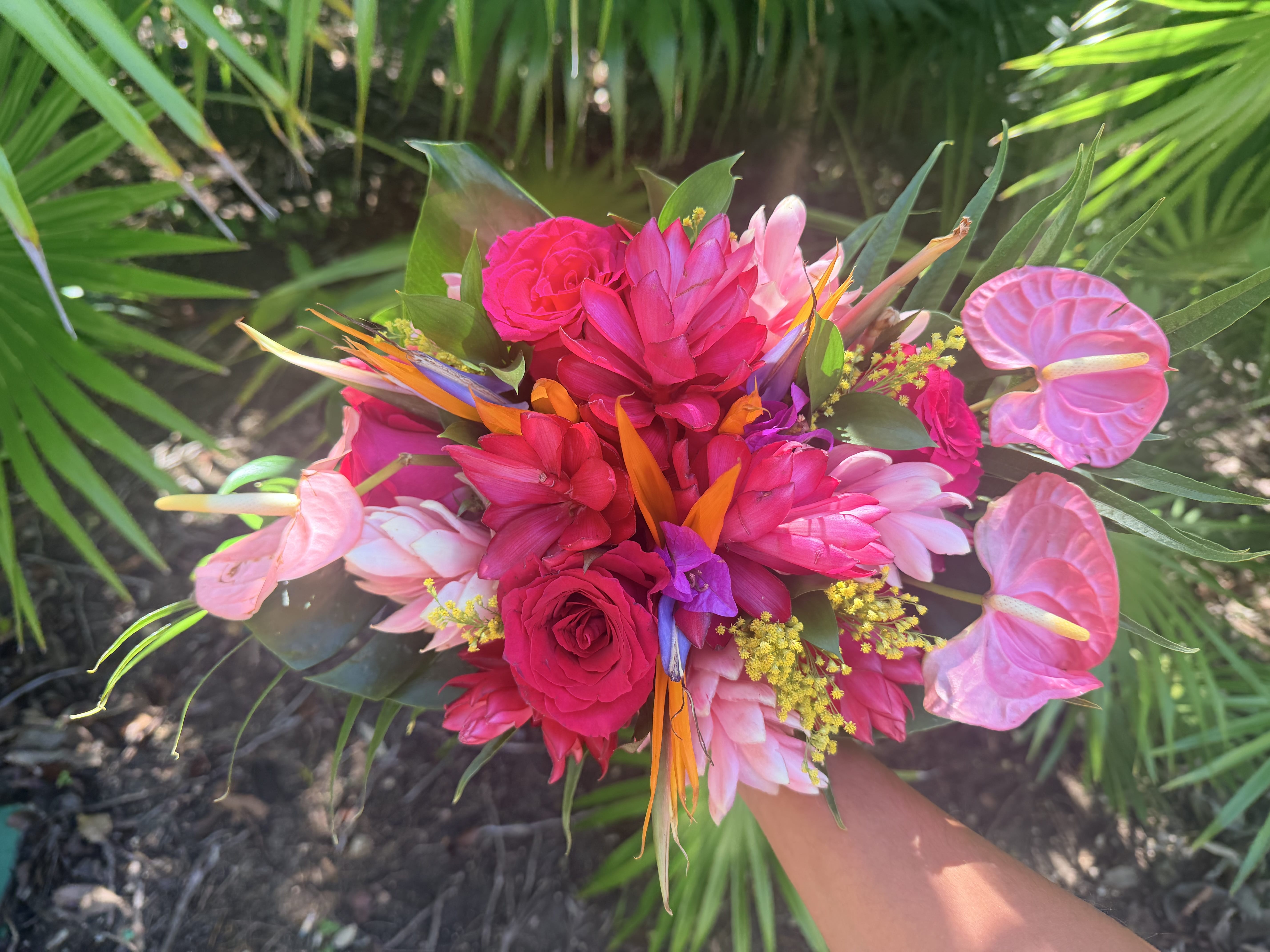 Hand holding the Hailey and Spencer bouquet with vibrant tropical flowers, perfect for a destination wedding.