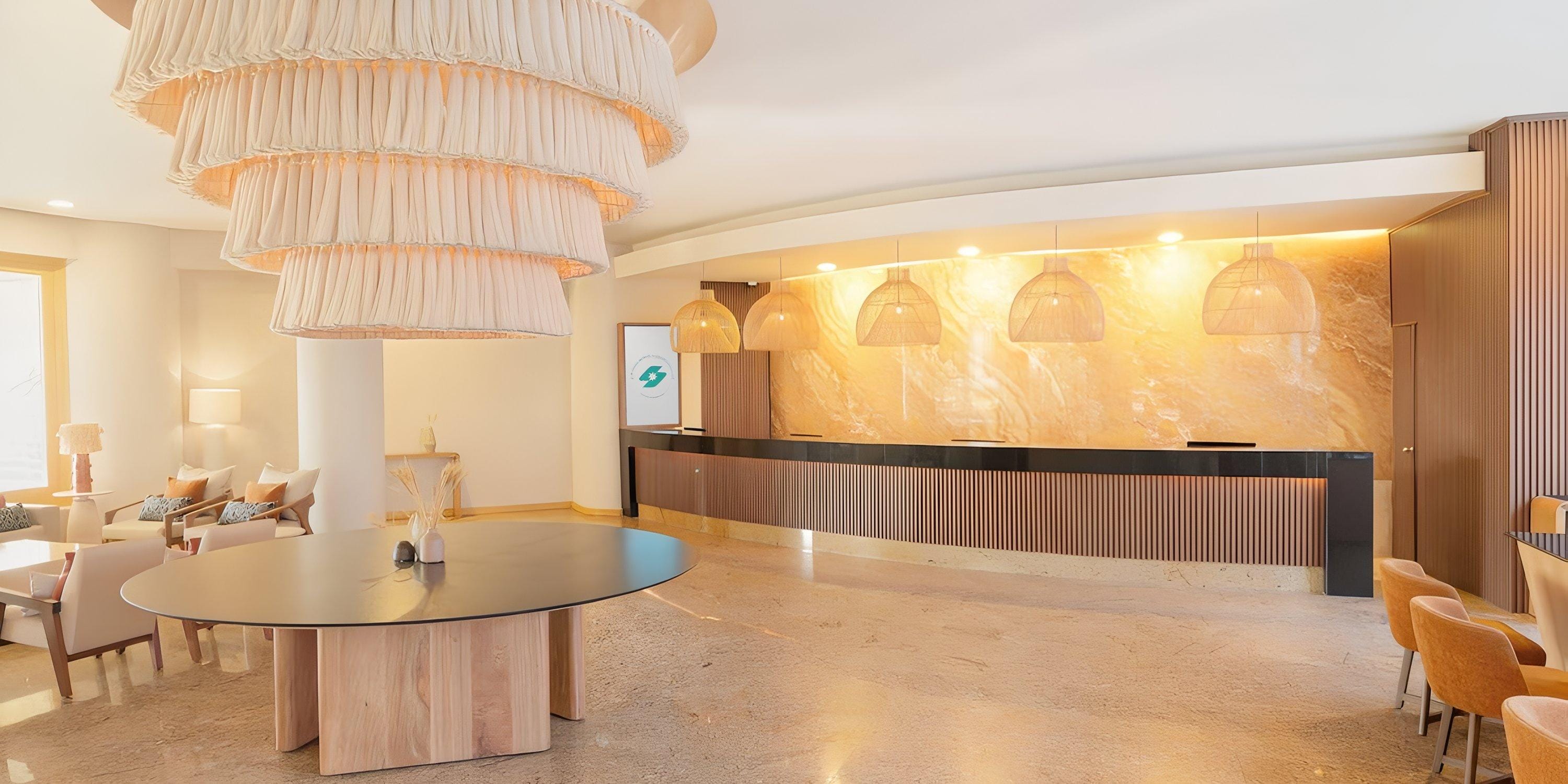 Barcel&oacute; Grand Faro Los Cabos lobby set for a destination wedding, featuring round table, chandelier, and reception desk.