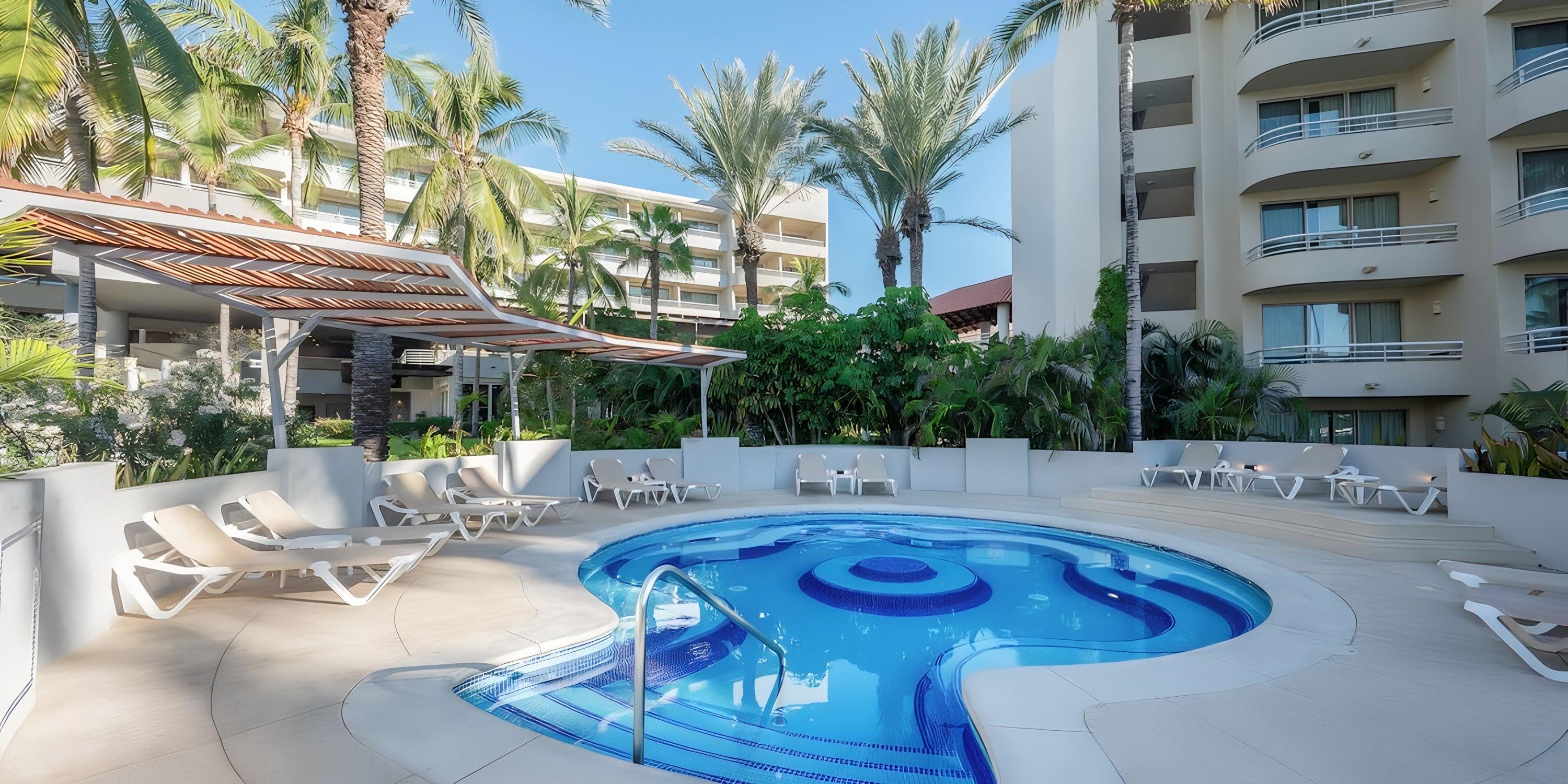 Barcel&oacute; Grand Faro Los Cabos: Circular pool with built-in seating, lounge chairs, palm trees&mdash;ideal for a destination wedding.