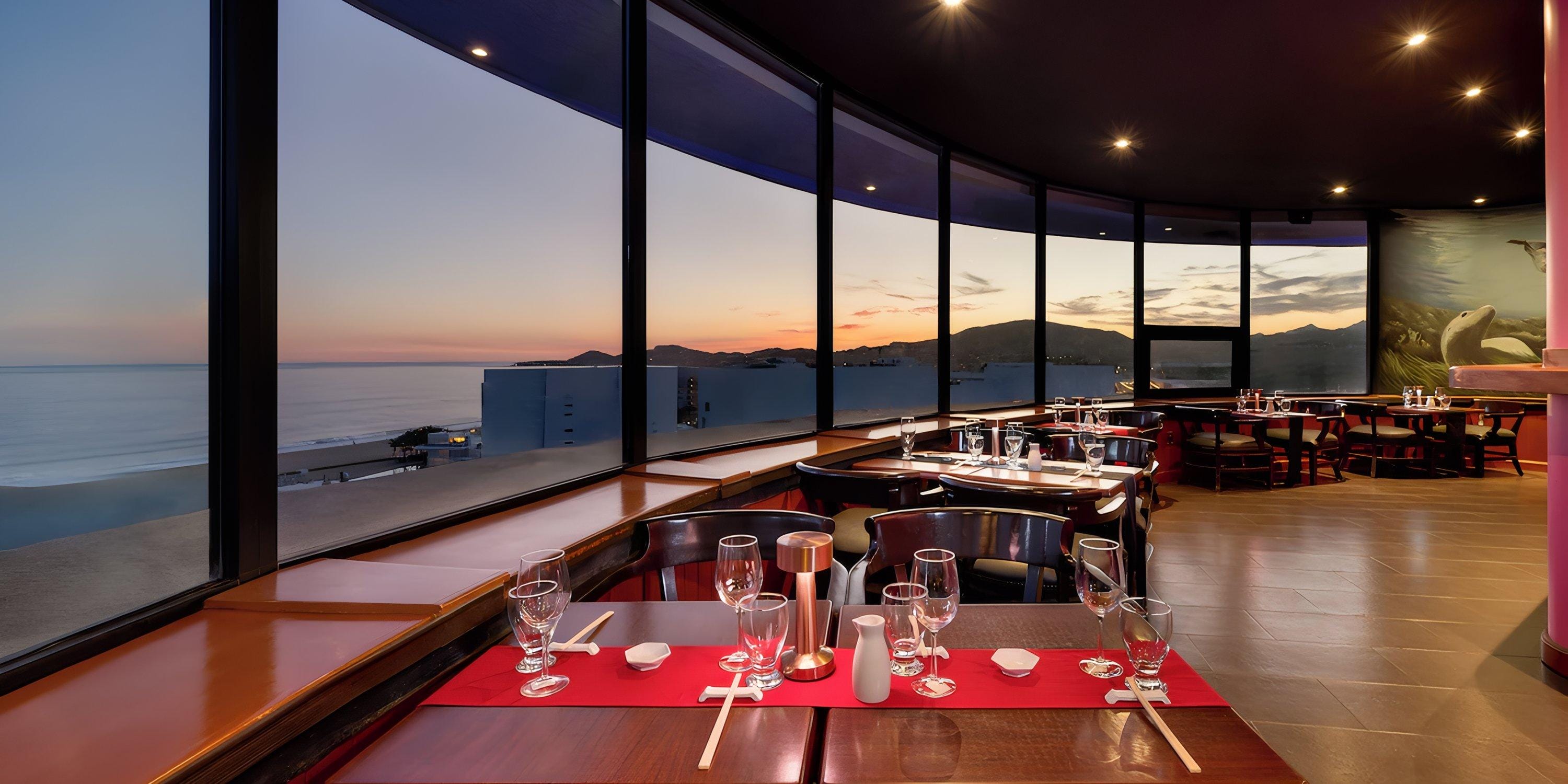 Barcel&oacute; Grand Faro Los Cabos: set tables and large windows with ocean sunset&mdash;perfect for a destination wedding.