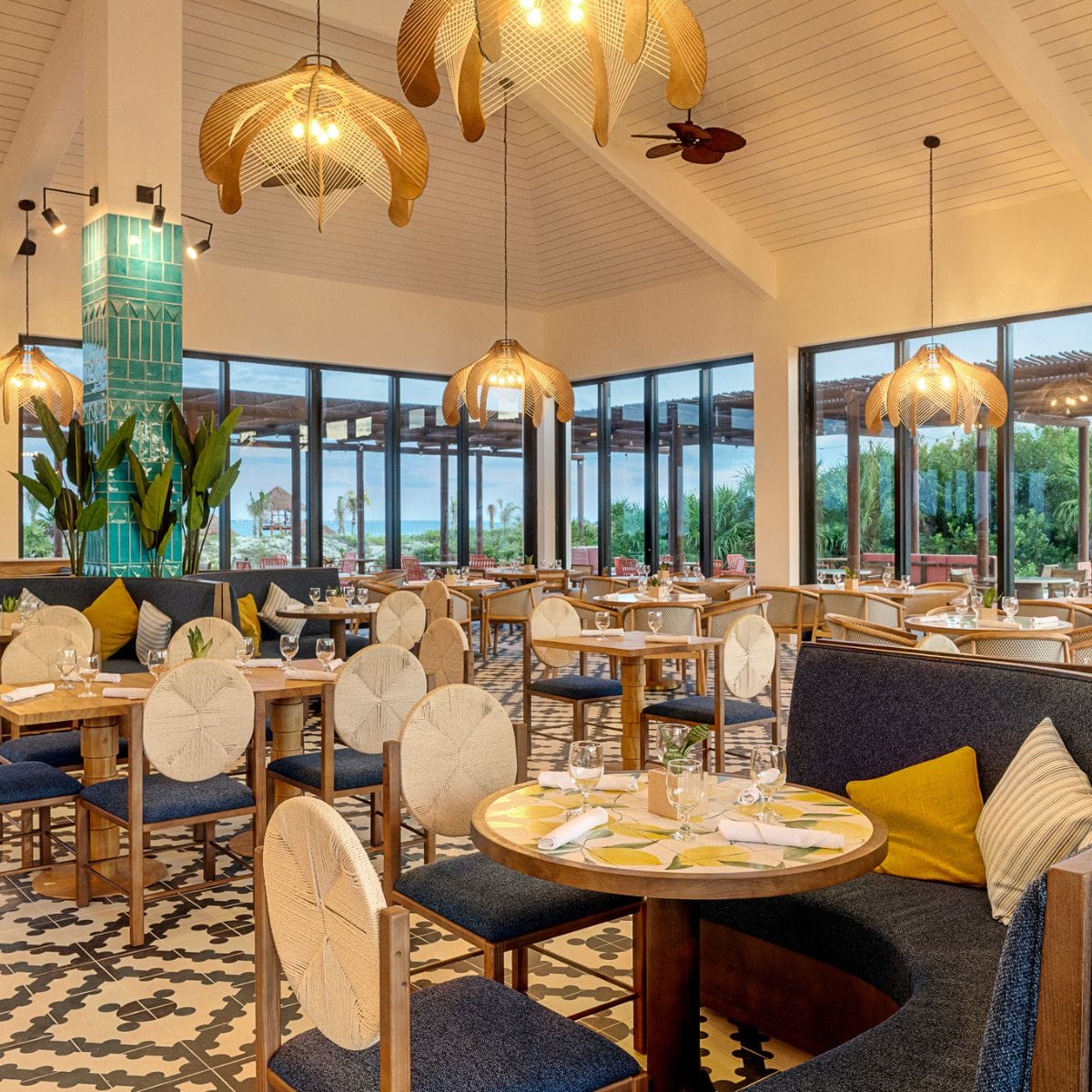 Elegant restaurant interior with round tables, plush chairs, and wide windows&mdash;ideal for a destination wedding.