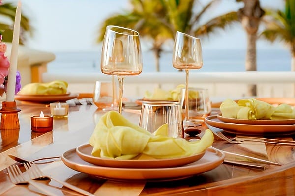 Outdoor dining set at Barcel&oacute; Grand Faro Los Cabos, ideal for a destination wedding, with yellow napkins.