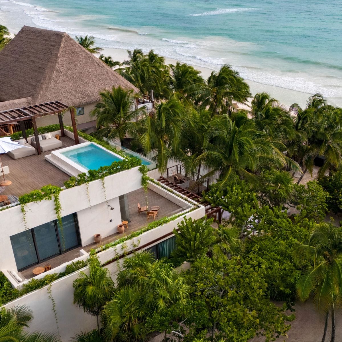 A modern beachfront villa perfect for a destination wedding, rooftop pool, palm trees, and ocean views.