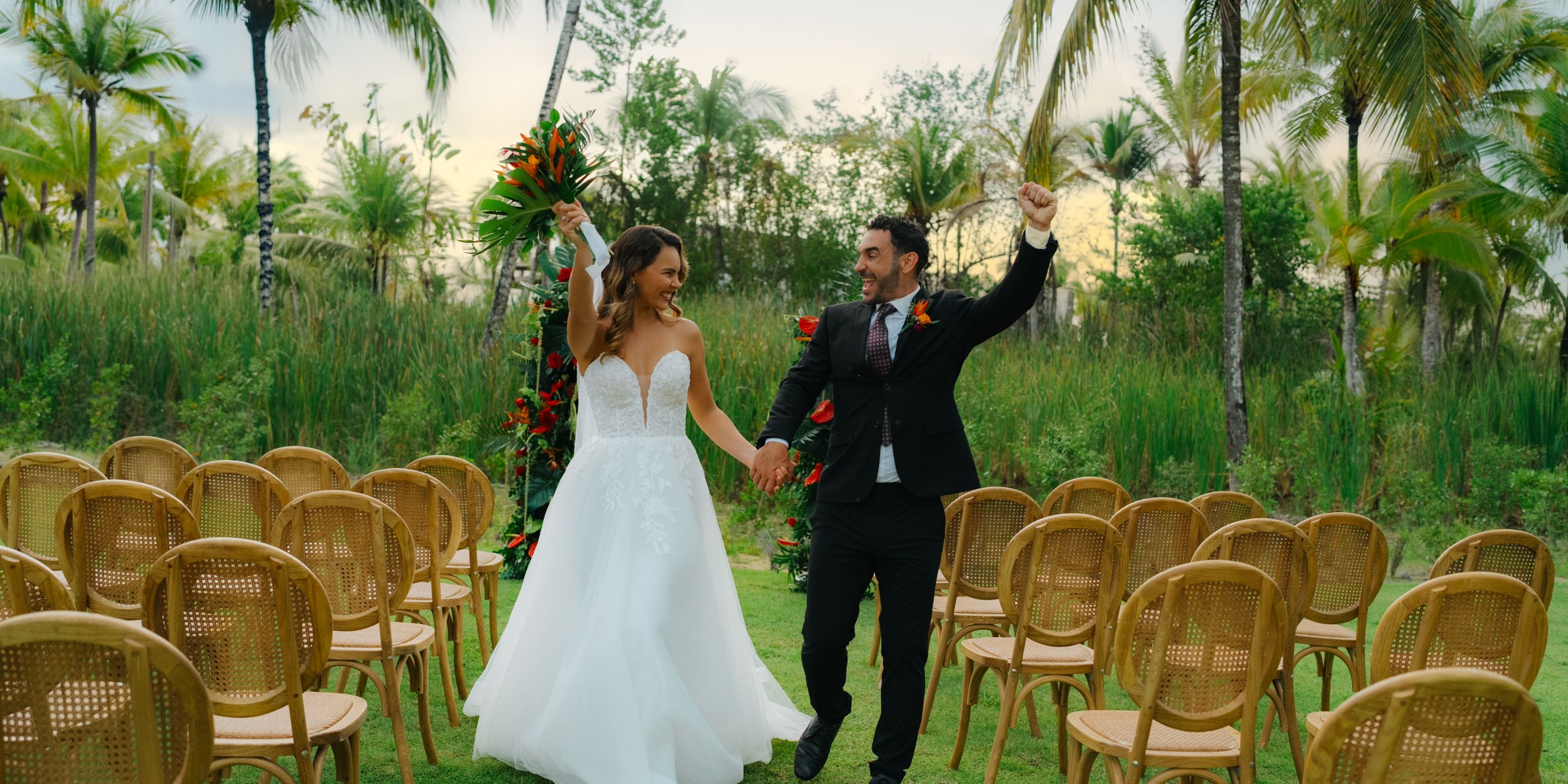 A couple celebrates their destination wedding along the outdoor aisle at Zemi Miches Punta Cana Resort.