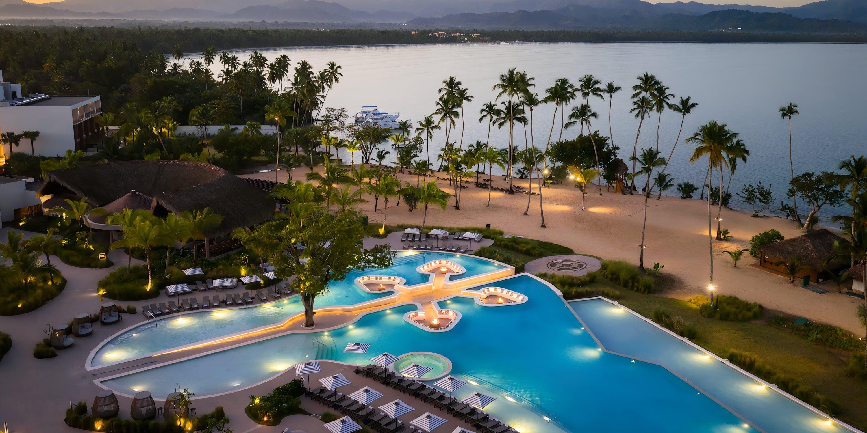 Aerial view of Hilton Cancun Mar Caribe's resort pool and beach at sunset, ideal for a destination wedding.