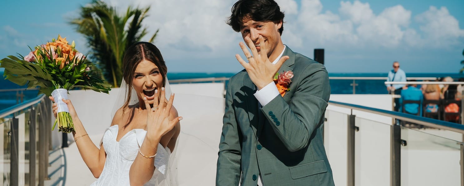 Bride and groom beaming outdoors, showing rings, joyful about destination wedding package prices.