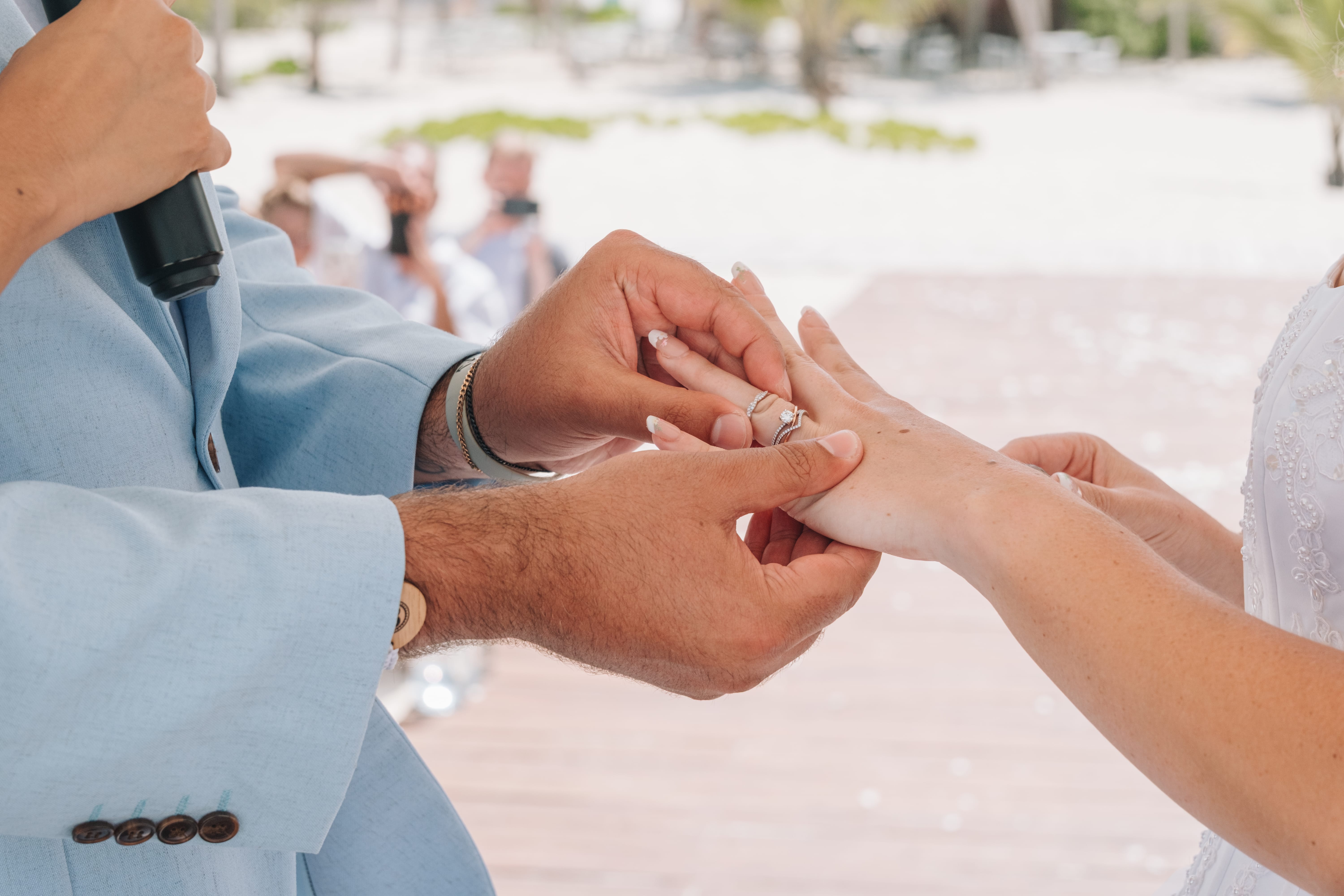 Kayleigh and Isaac exchange rings during their outdoor destination wedding ceremony.