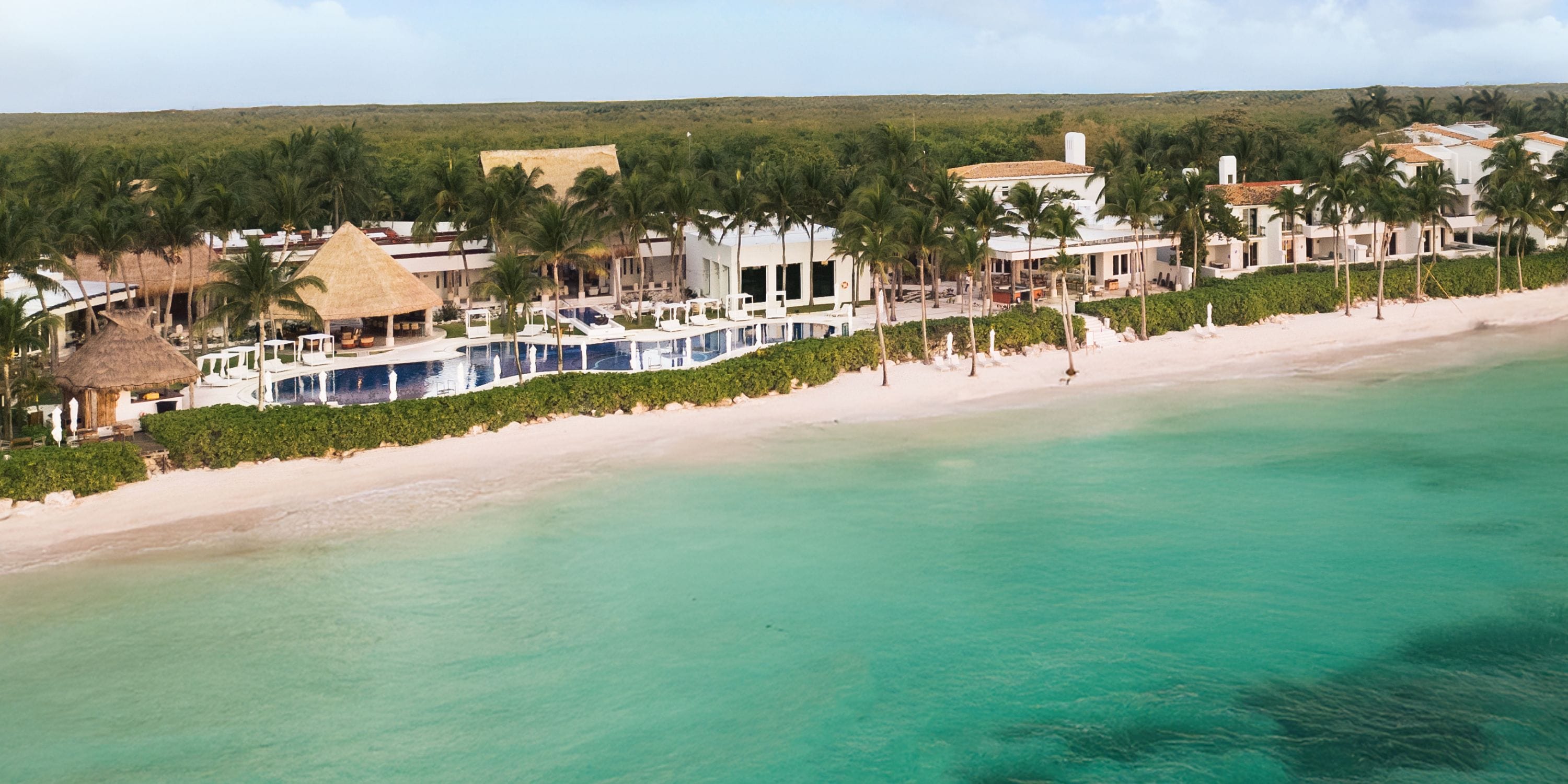 Royalton Riviera Cancun: a beachfront resort with pools, palm trees, and destination wedding sands.