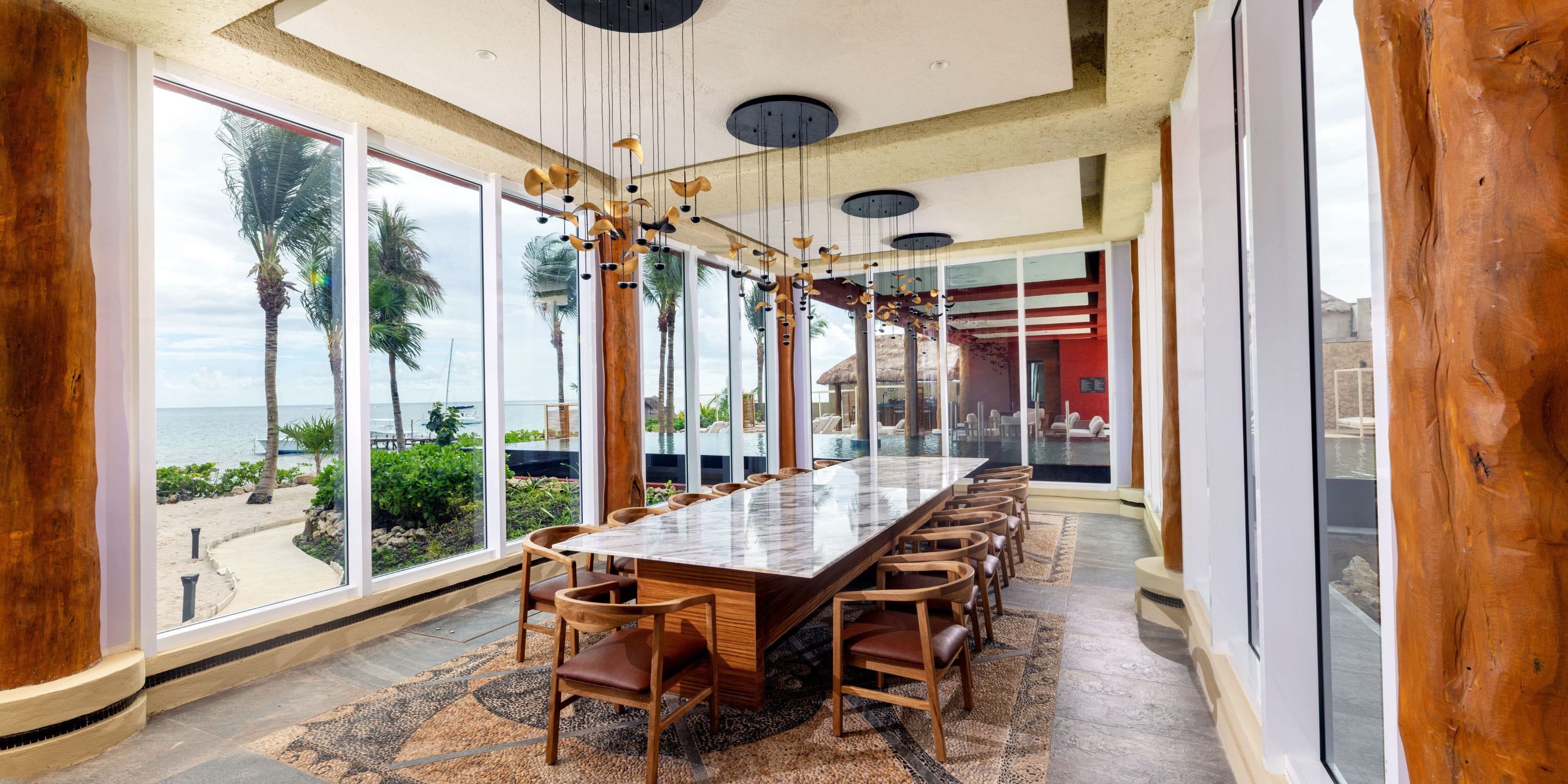 Elegant modern dining with a large table, ocean views, and destination wedding ambiance.