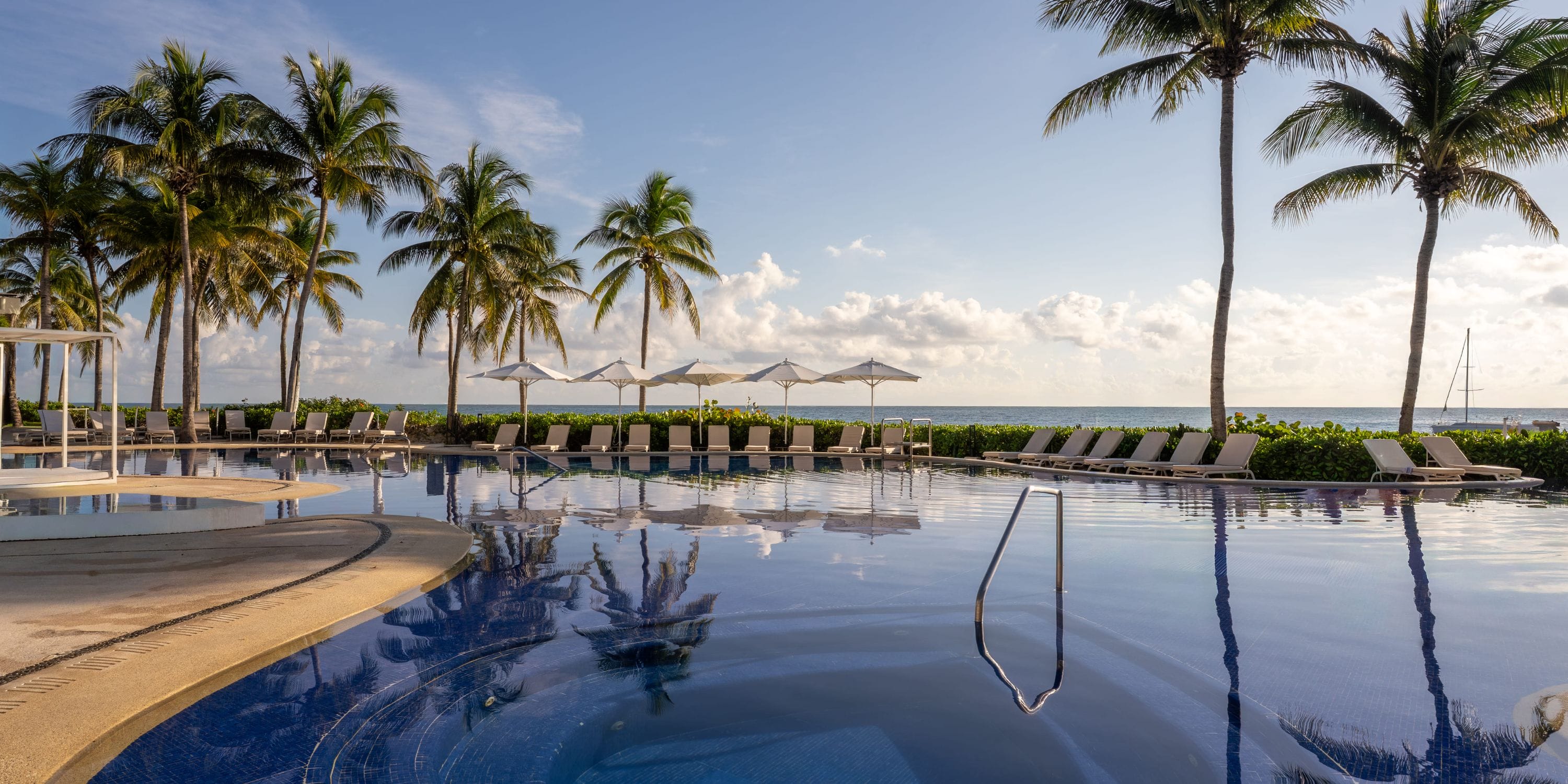 Relax by the Royalton Riviera Cancun pool, an ideal setting for your dream destination wedding.