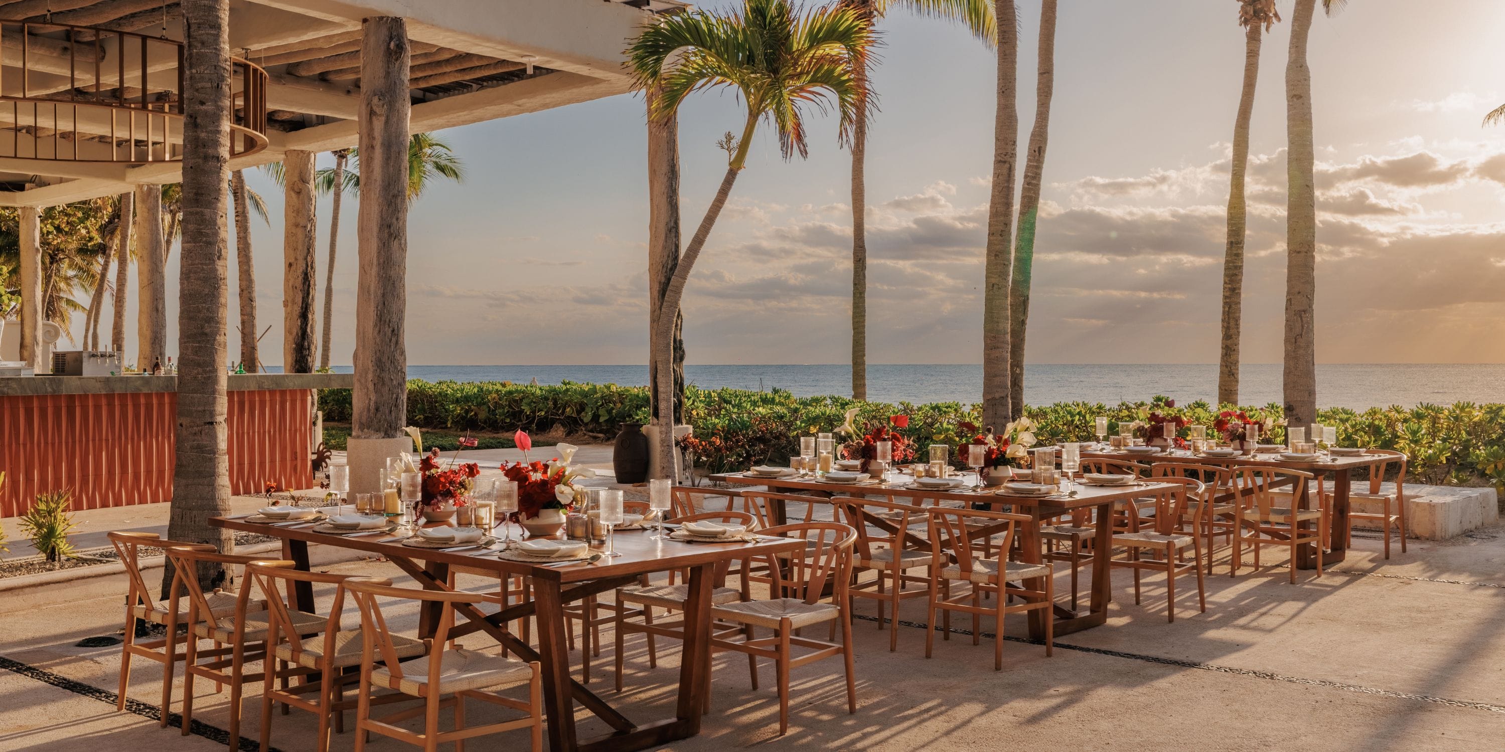 Elegant destination wedding tables by the ocean at Royalton Riviera Cancun, sunset and palm trees.
