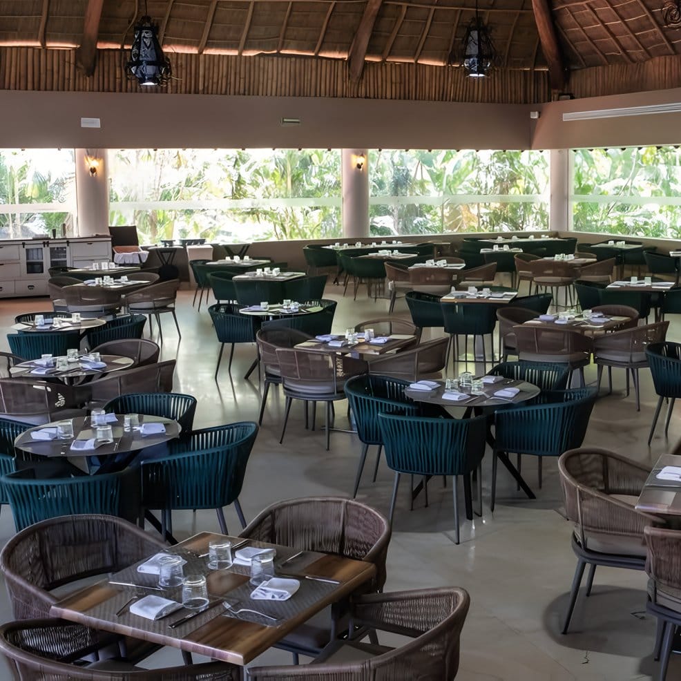 Elegant restaurant interior set for a destination wedding, round tables and chairs arranged neatly.