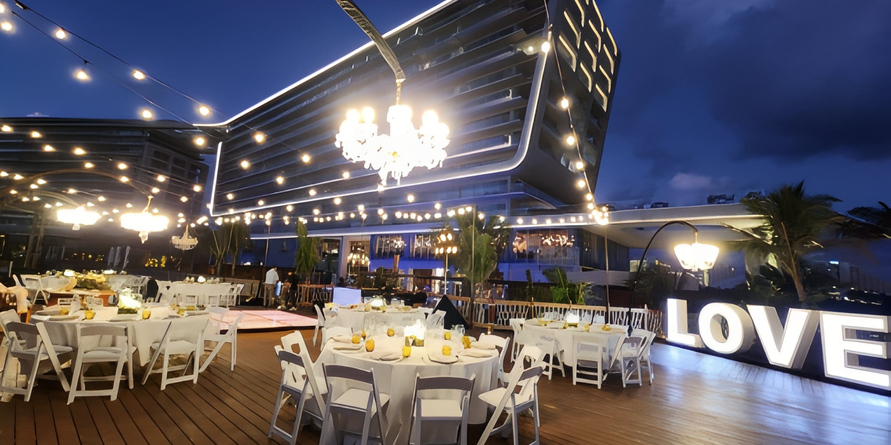 Outdoor deck at Mondrian Cancun All Inclusive set for a destination wedding with lights and letters.
