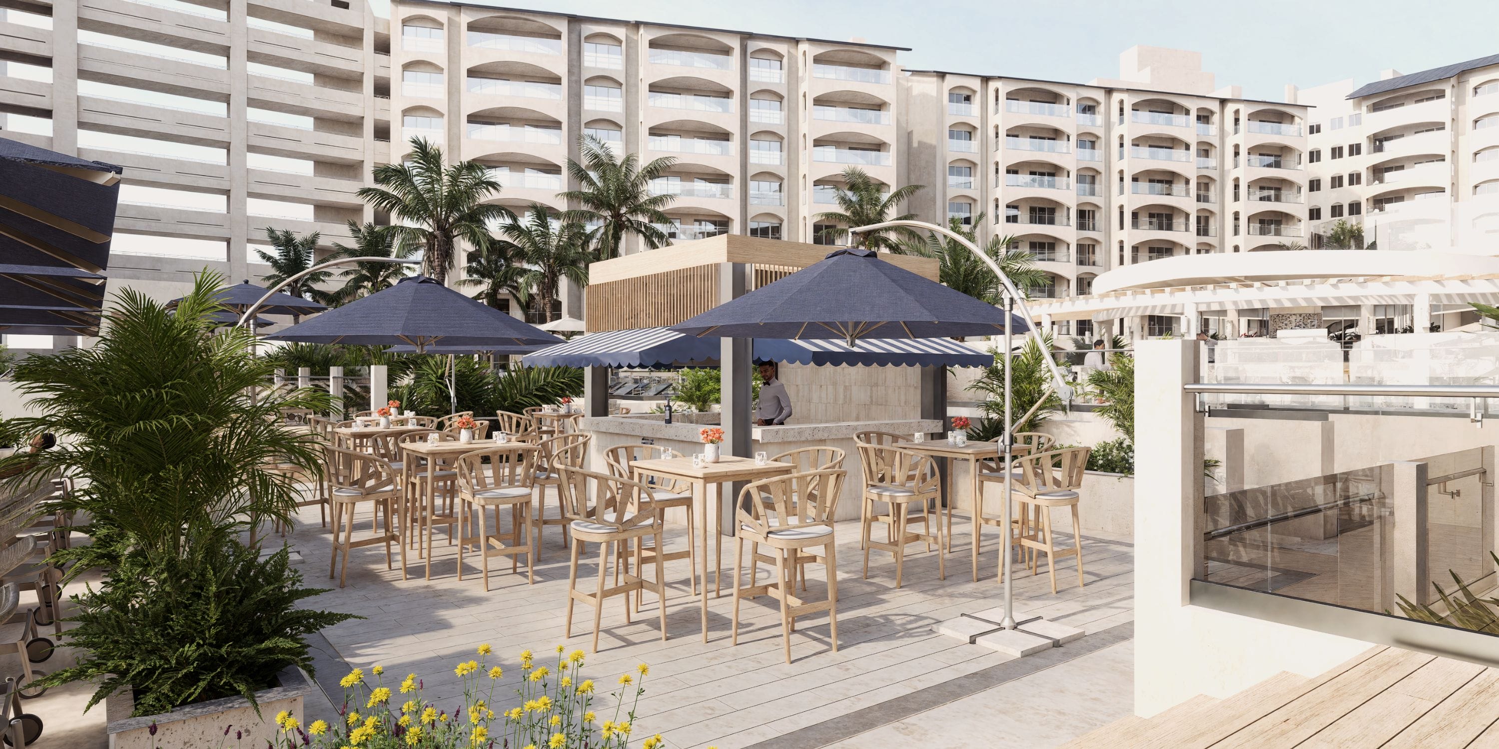 Destination wedding dining at Royalton Riviera Cancun: wooden tables, blue umbrellas, palm trees.