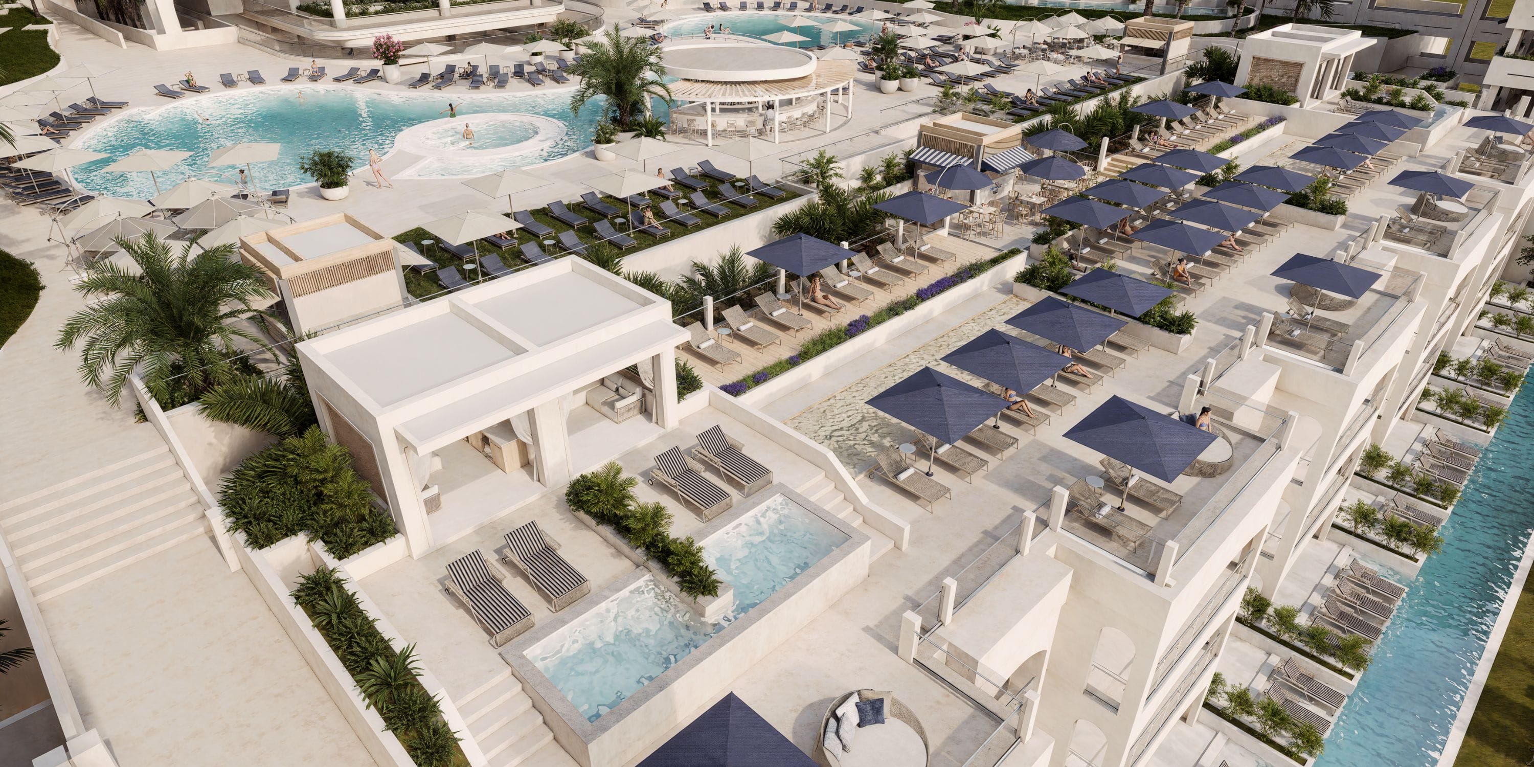 Aerial view of Royalton Riviera Cancun, a destination wedding resort with pools and blue umbrellas.