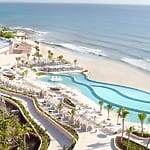 A beachfront resort with pools, palms, and destination wedding packages by the ocean.