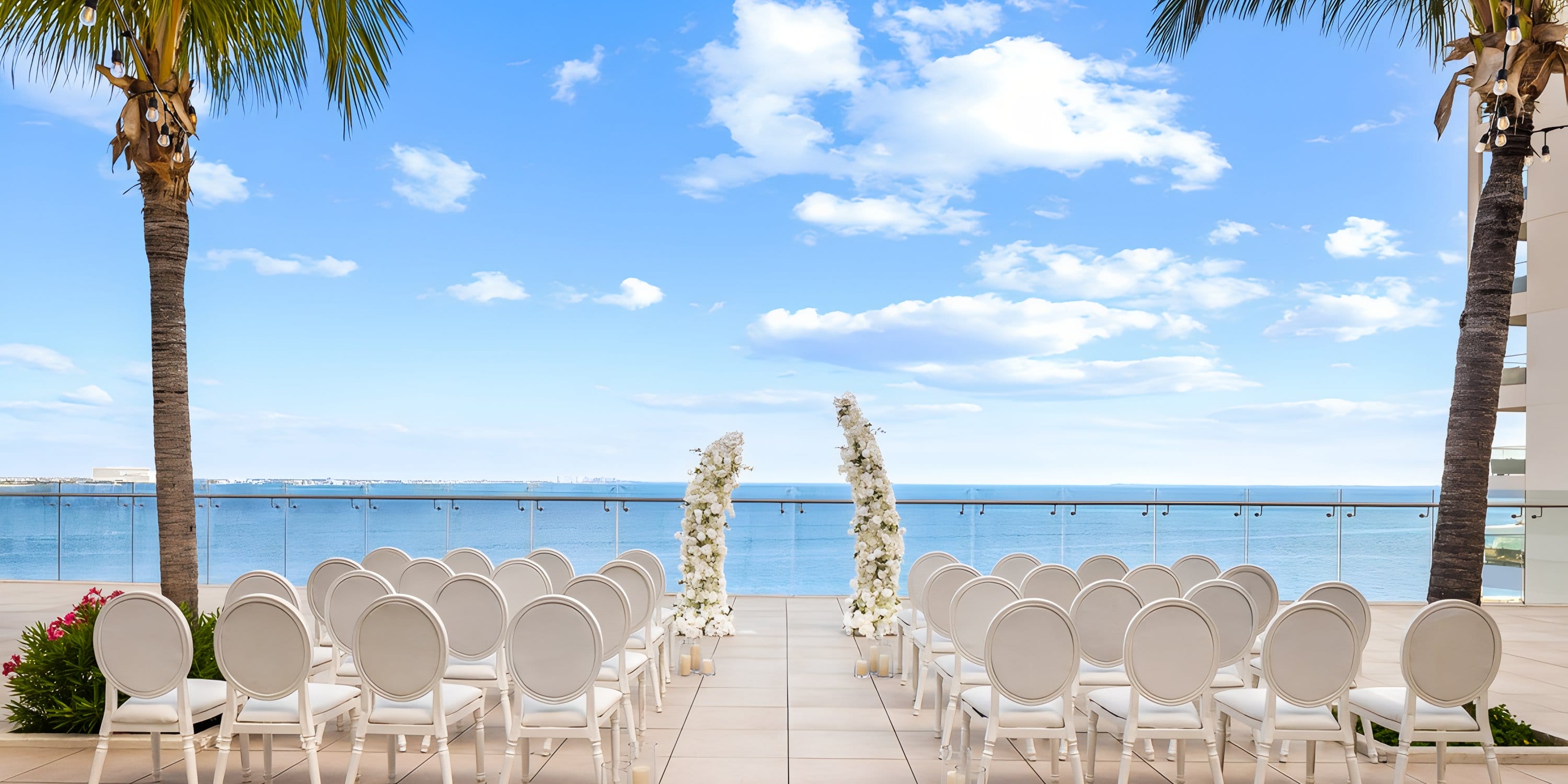 White chairs face floral arches on a terrace, set up for a destination wedding at the resort.