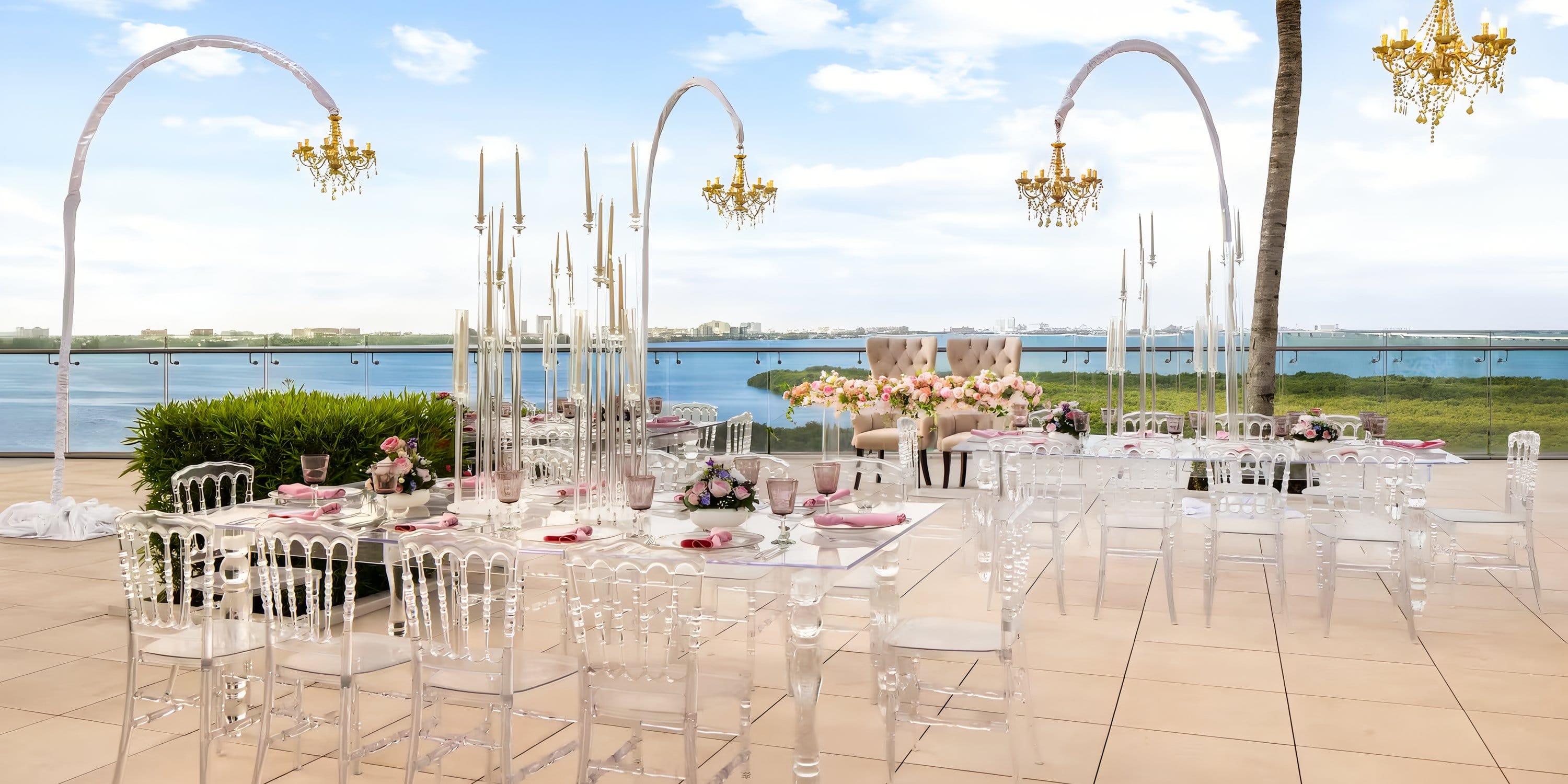 Chic destination wedding by the water at Breathless Cancún Soul Resort with clear chairs.