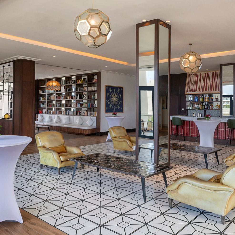 Modern lounge, yellow chairs, geometric floor—ideal for a chic destination wedding reception.