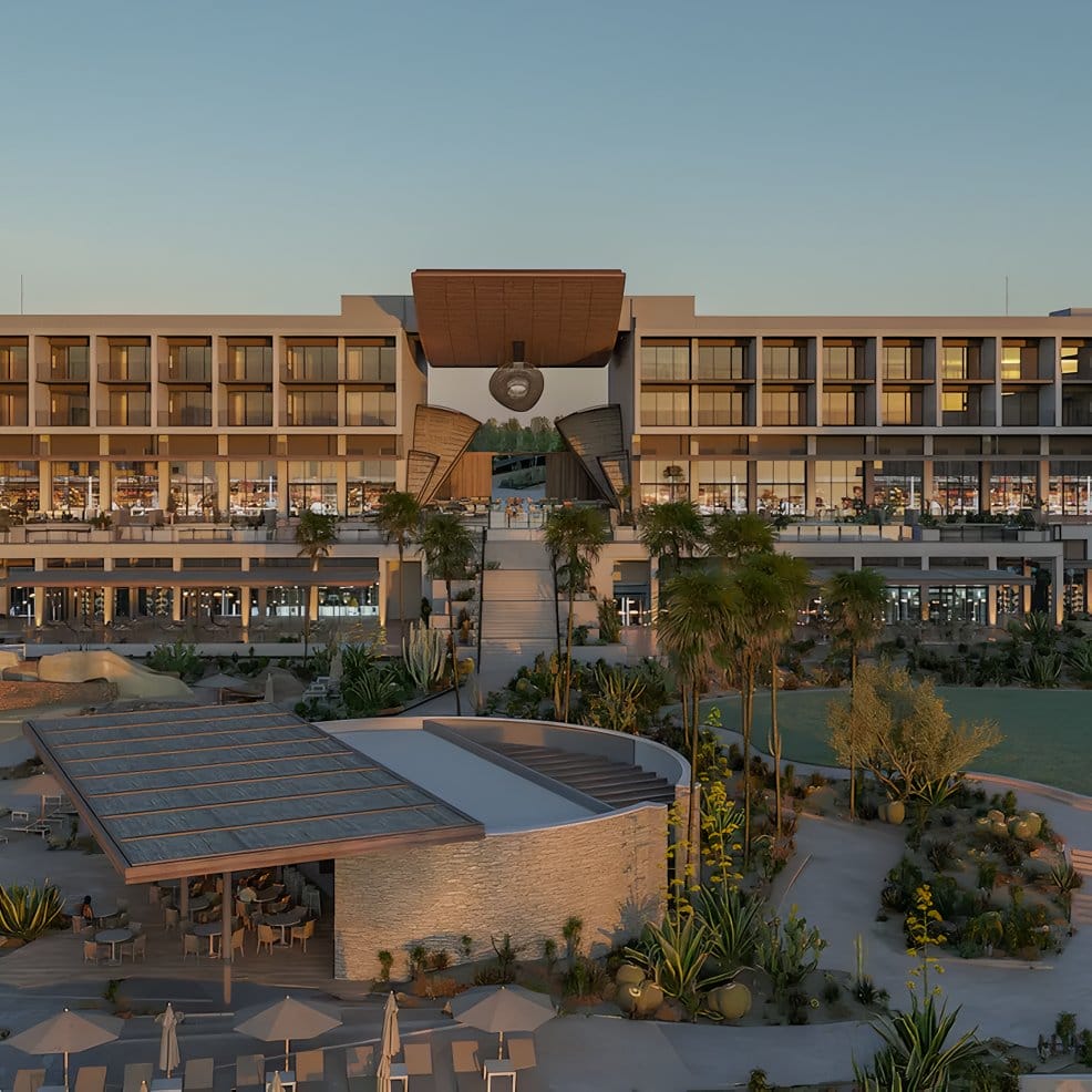 Modern hotel with large central arch, palm trees, and seating—perfect for a destination wedding.