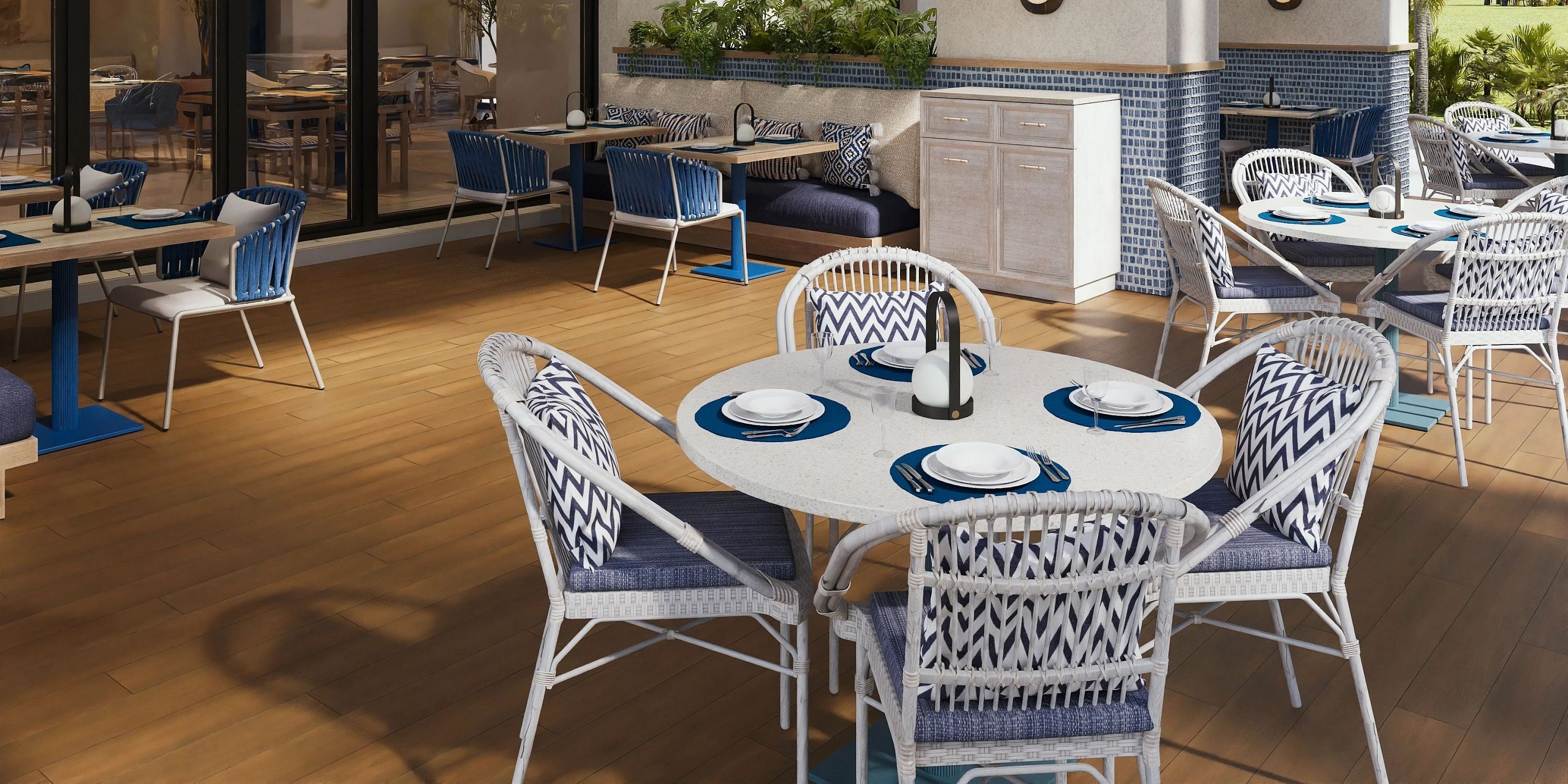 Dreams Macao Beach patio set for a destination wedding: round tables, blue chairs, no guests.