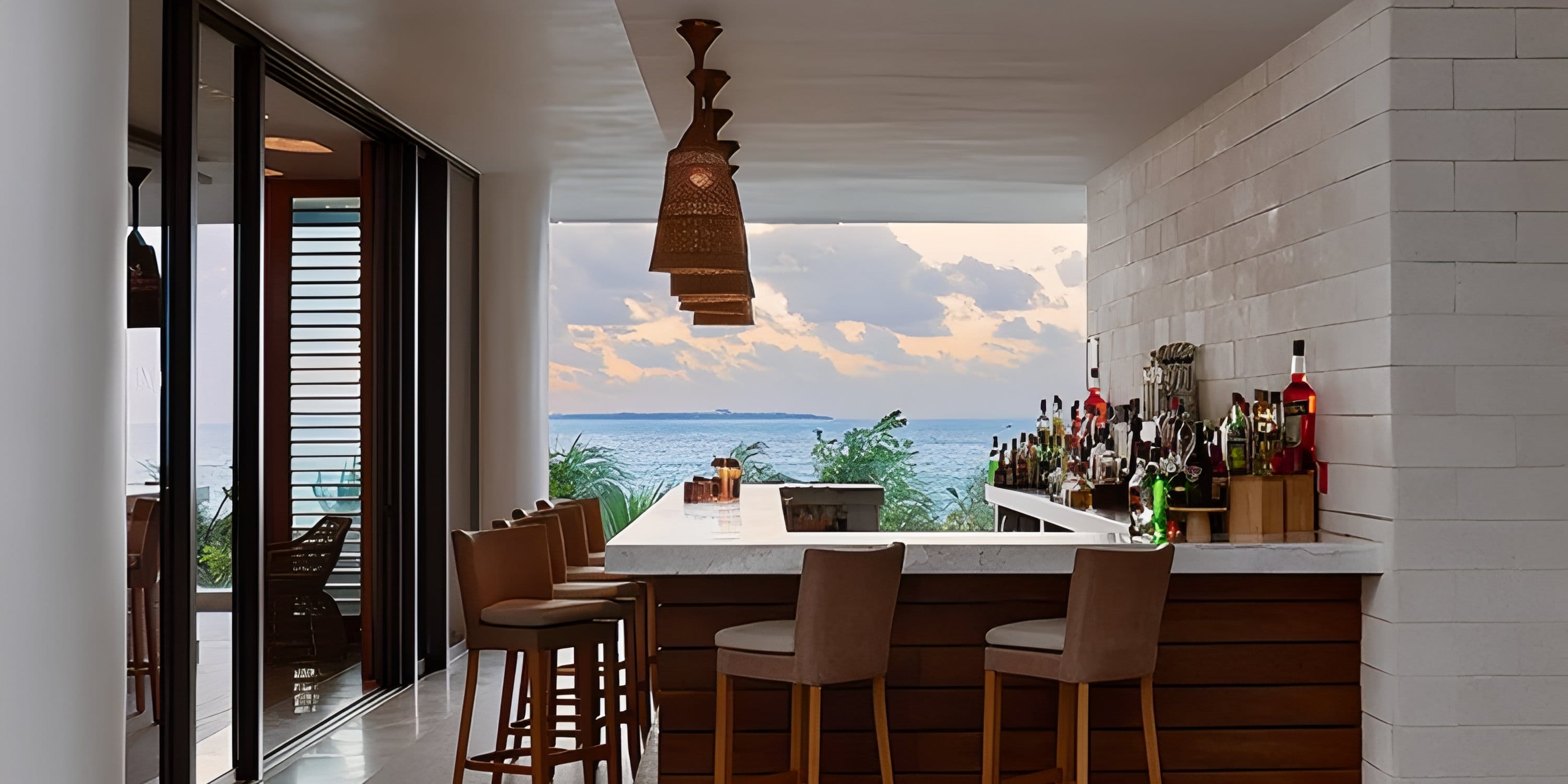Dreams Playa Mujeres outdoor bar with stools, a perfect spot for a destination wedding at sunset.