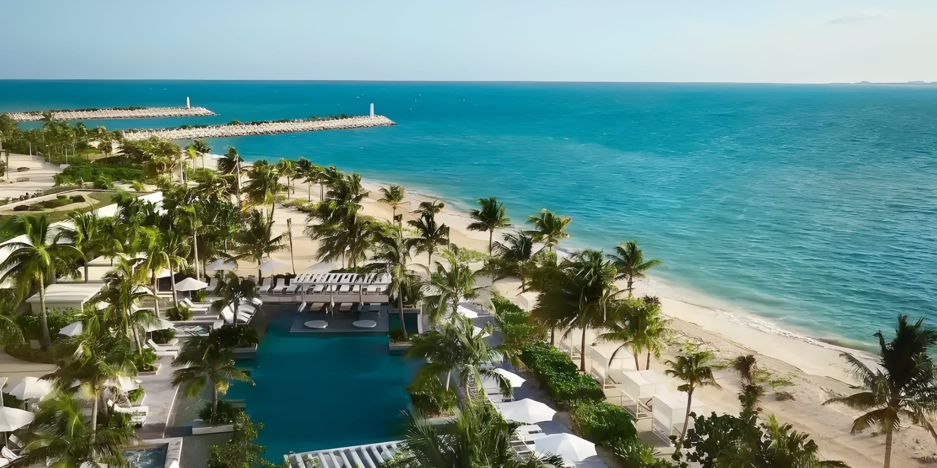 Aerial view of Dreams Playa Mujeres, a destination wedding spot with a pool, palms, and a pier.