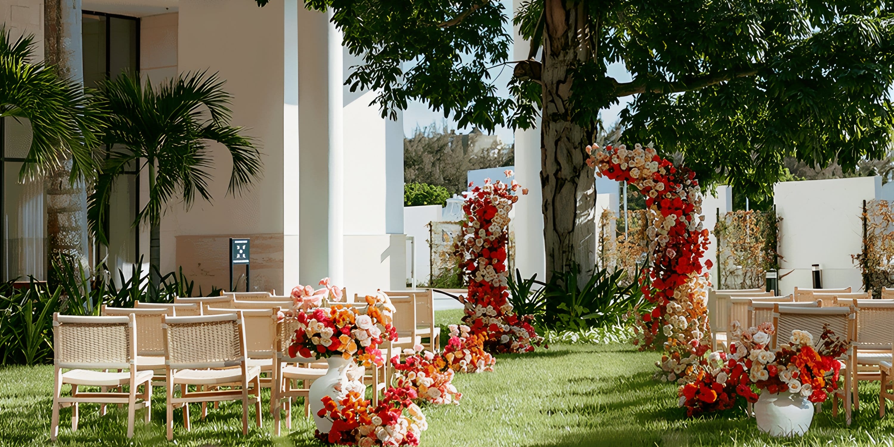Rows of chairs on a lawn facing floral arches for a Dreams Playa Mujeres wedding ceremony.