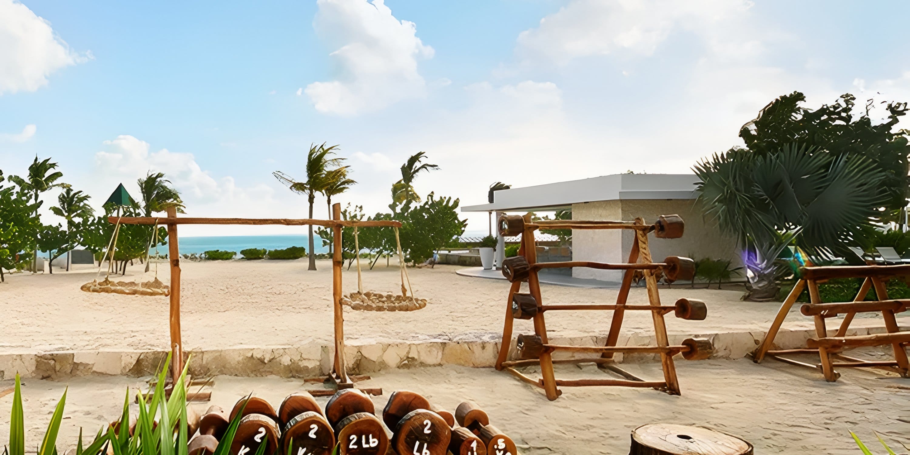 Wooden exercise equipment on a sandy beach at Dreams Playa Mujeres, a destination wedding spot.