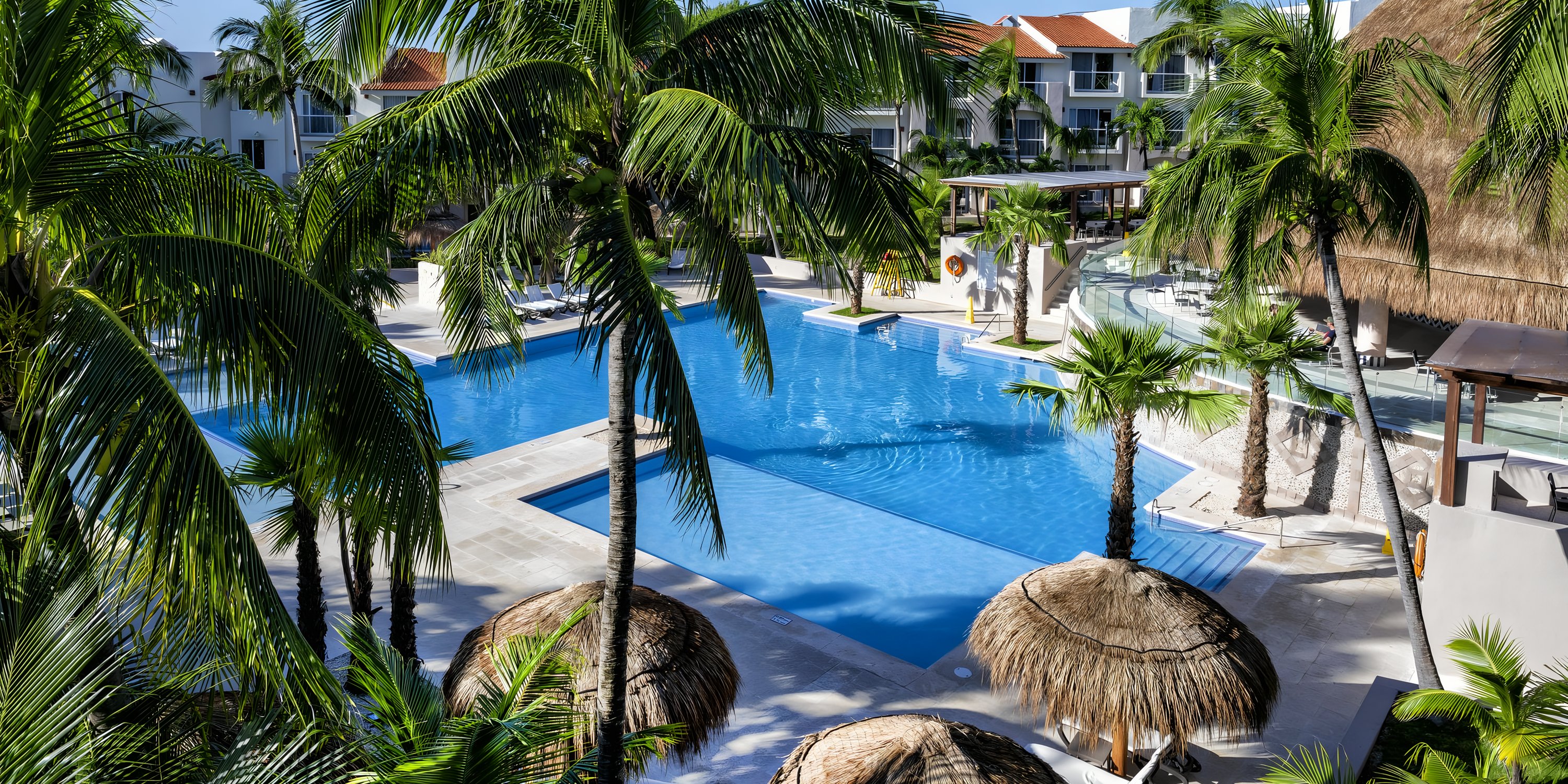 Swimming pool at Viva Maya by Wyndham, a perfect destination wedding spot framed by palms.