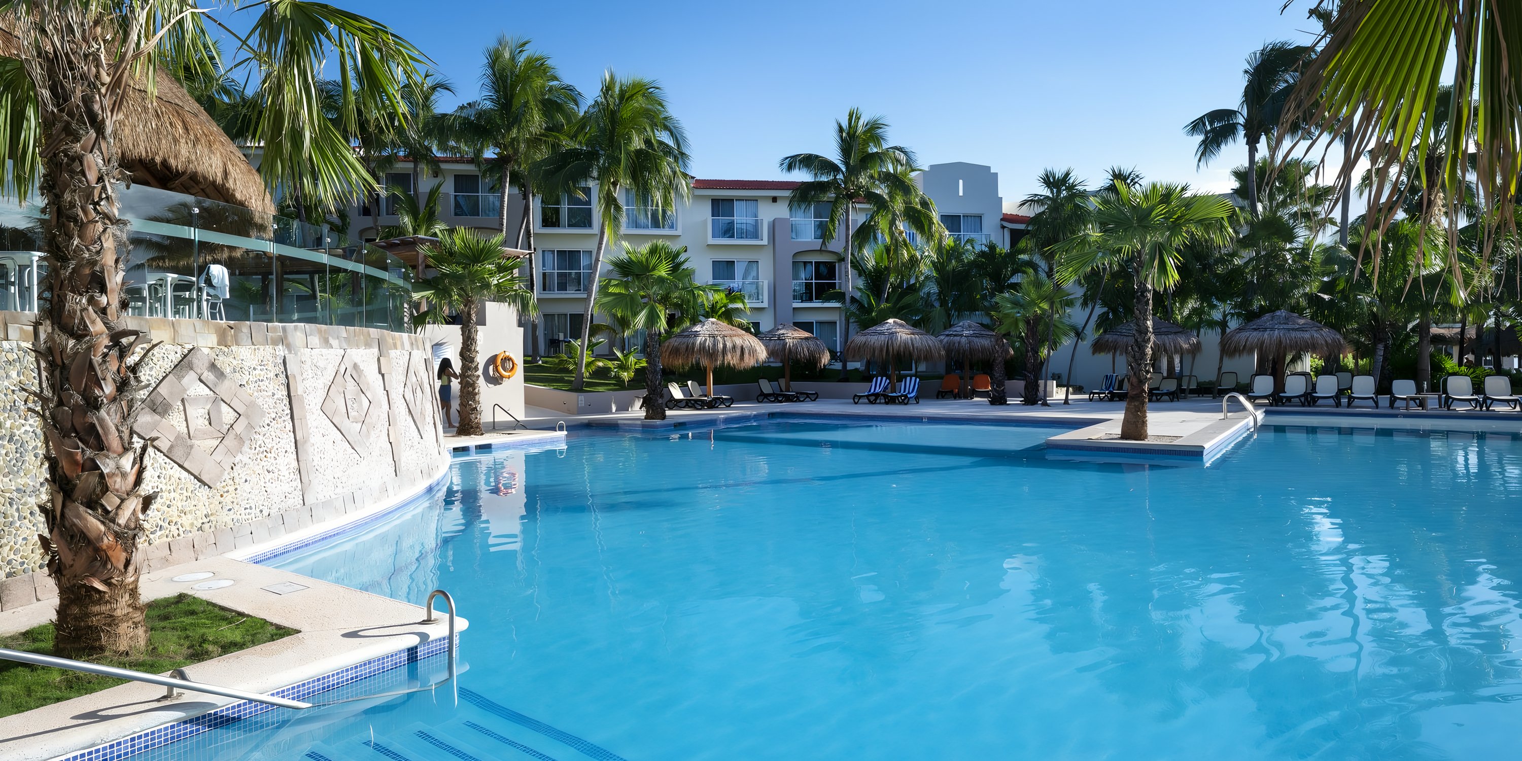 Swimming pool at Viva Maya by Wyndham, a perfect destination wedding resort with palm trees.