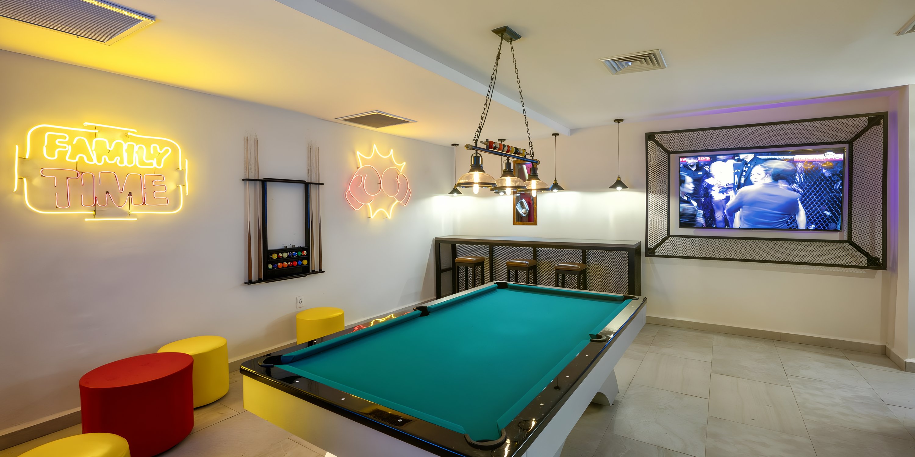 Game room at Viva Maya, a destination wedding resort, with a pool table, neon signs, and a TV.