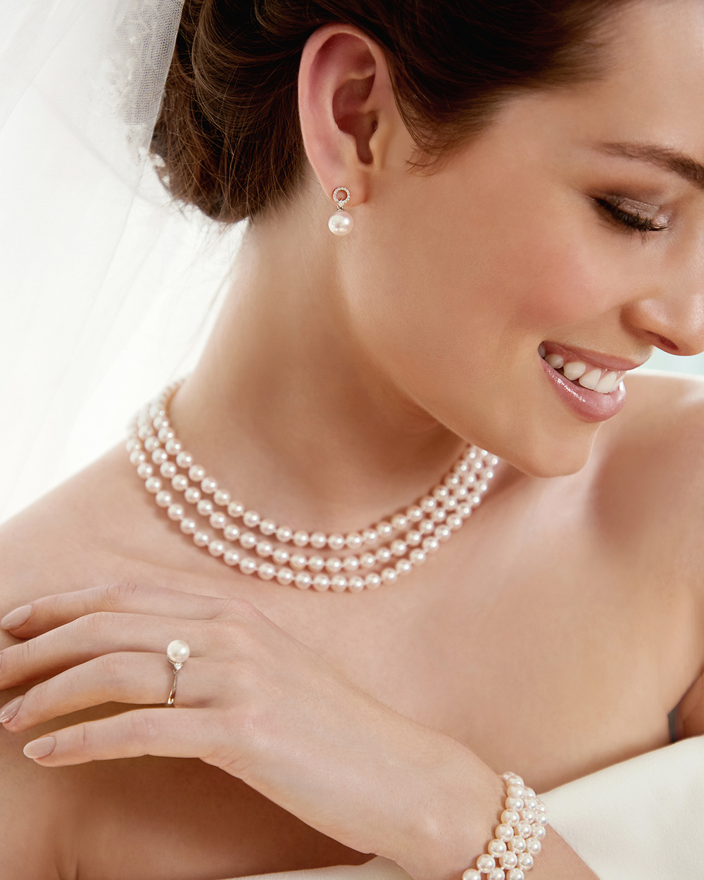 A smiling bride wearing pearl jewelry for her destination wedding.