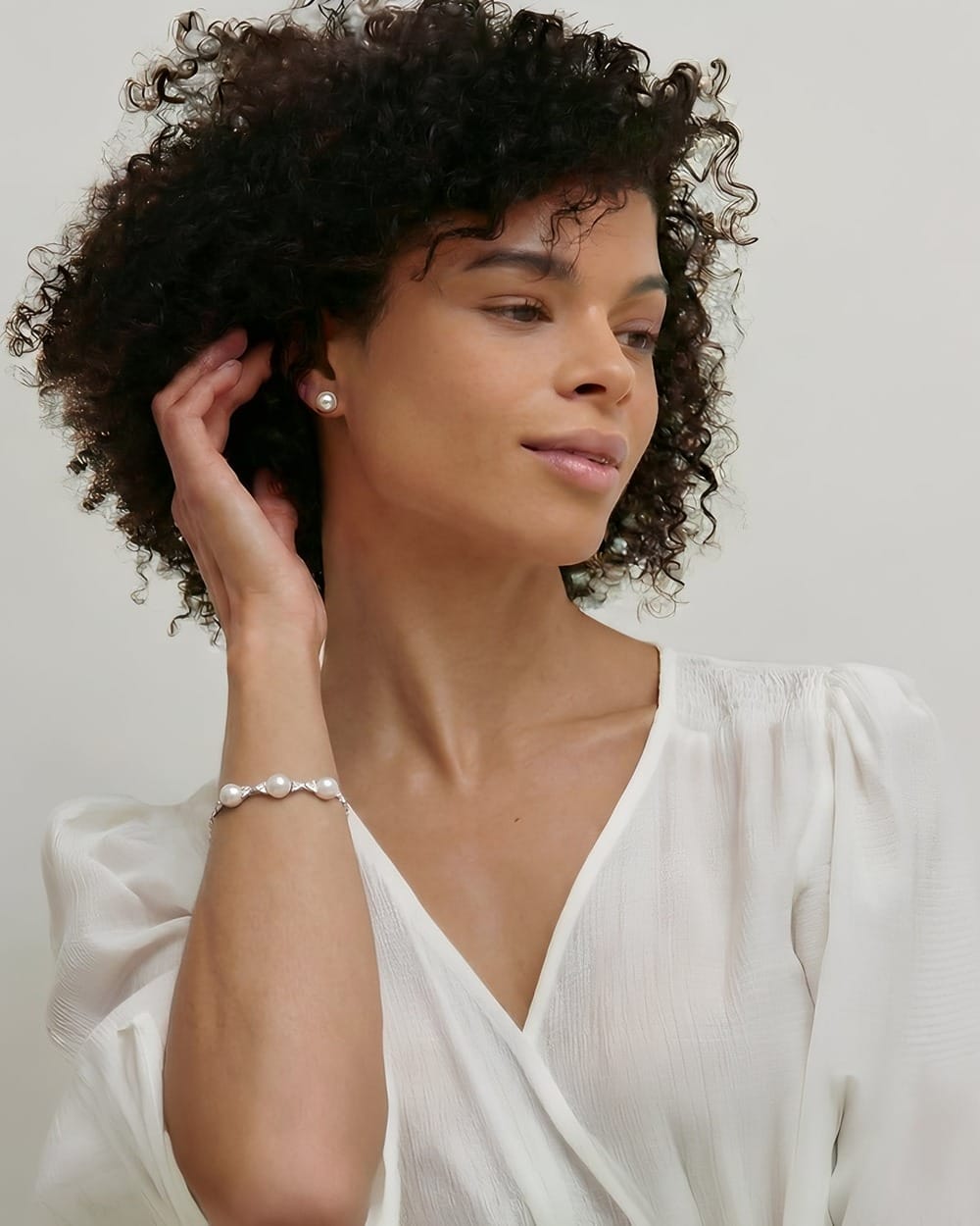 Model wearing pearl earrings and a bracelet, the perfect accessory for a destination wedding.