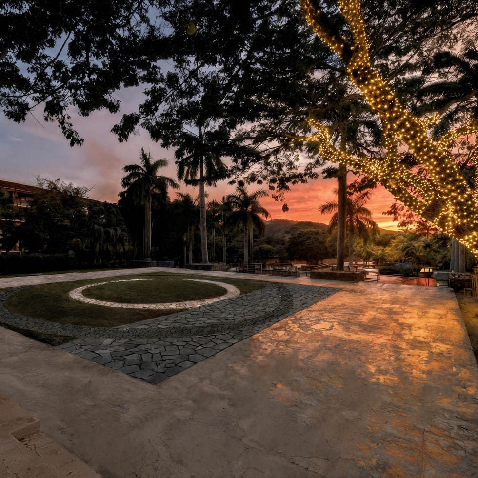 Sunset over a destination wedding venue with trees wrapped in fairy lights.