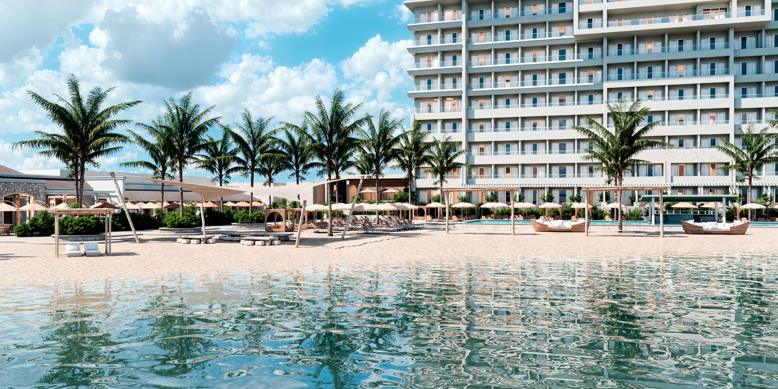 Royalton CHIC Antigua beachfront resort with palm trees and sun loungers set for a wedding.