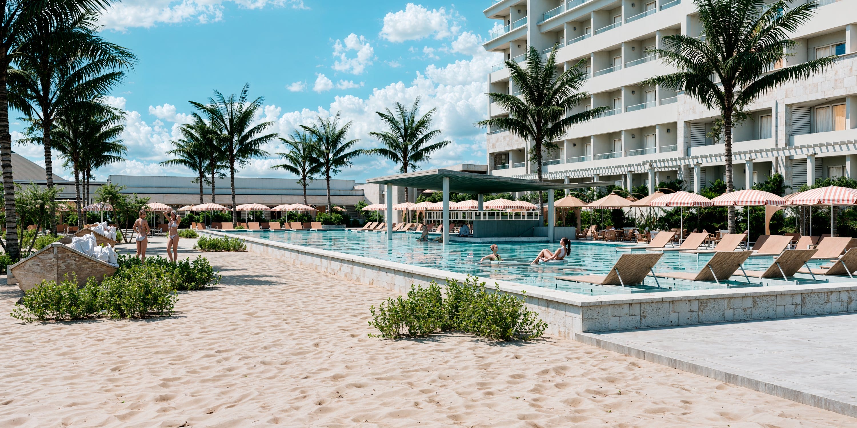 Guests enjoy a destination wedding pool at Royalton CHIC Antigua, near sand and palm trees.