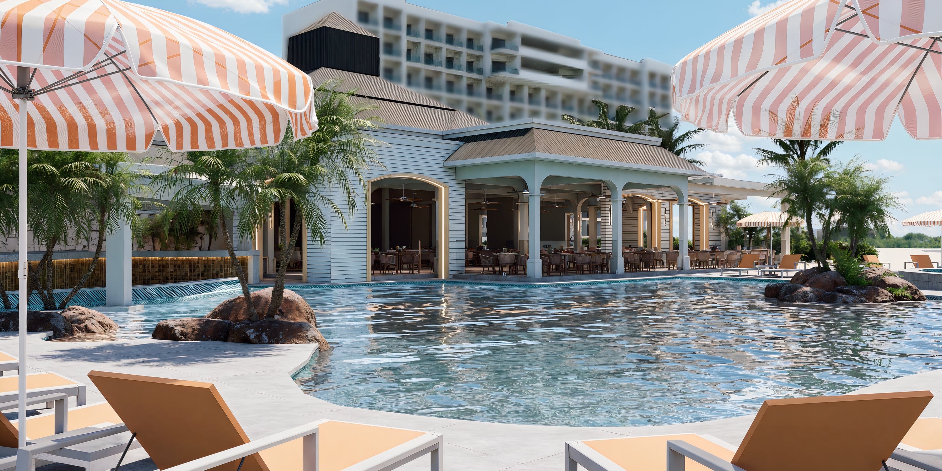 Royalton CHIC Antigua resort swimming pool with lounge chairs, umbrellas, and wedding restaurant.