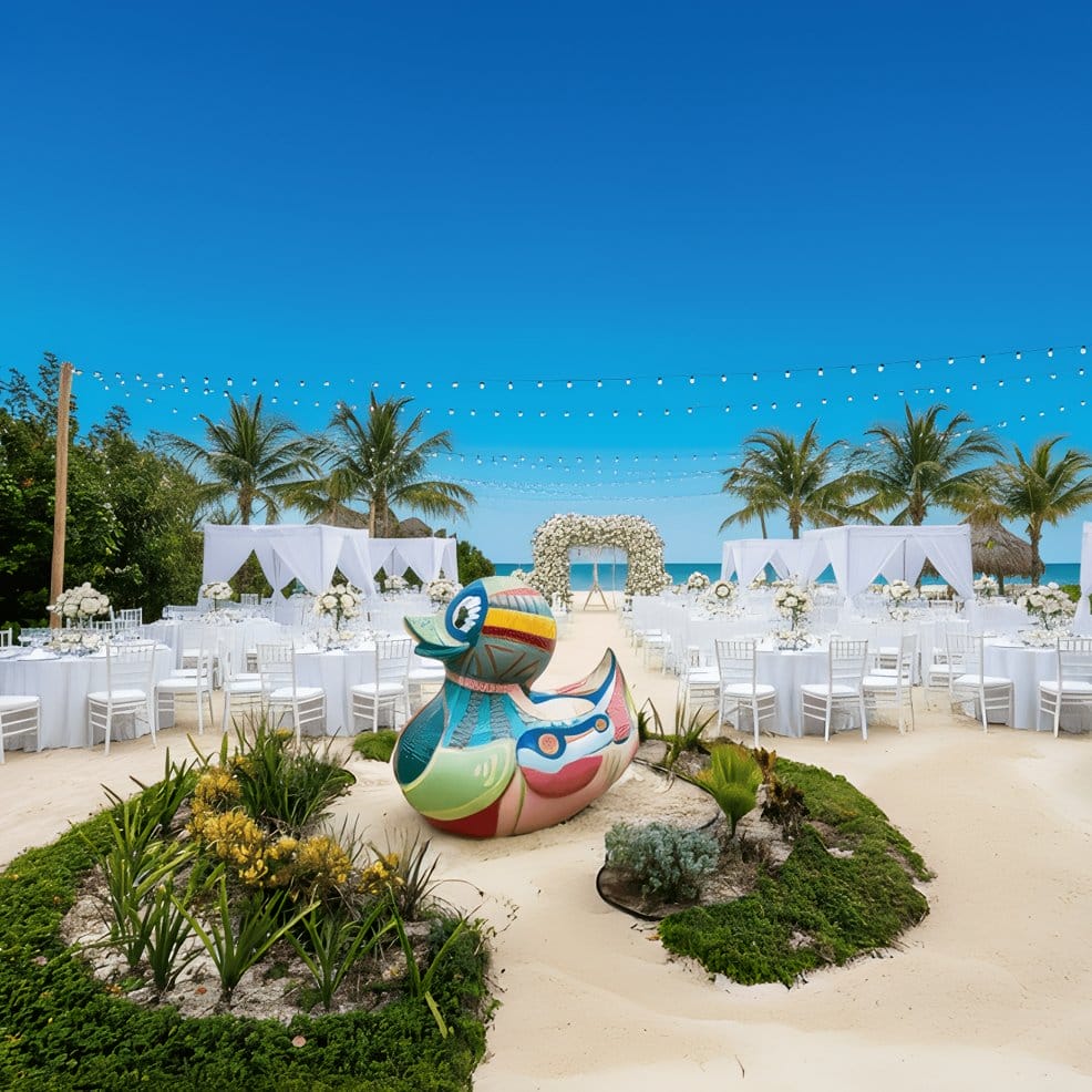 A giant painted rubber duck sculpture at a beach destination wedding.