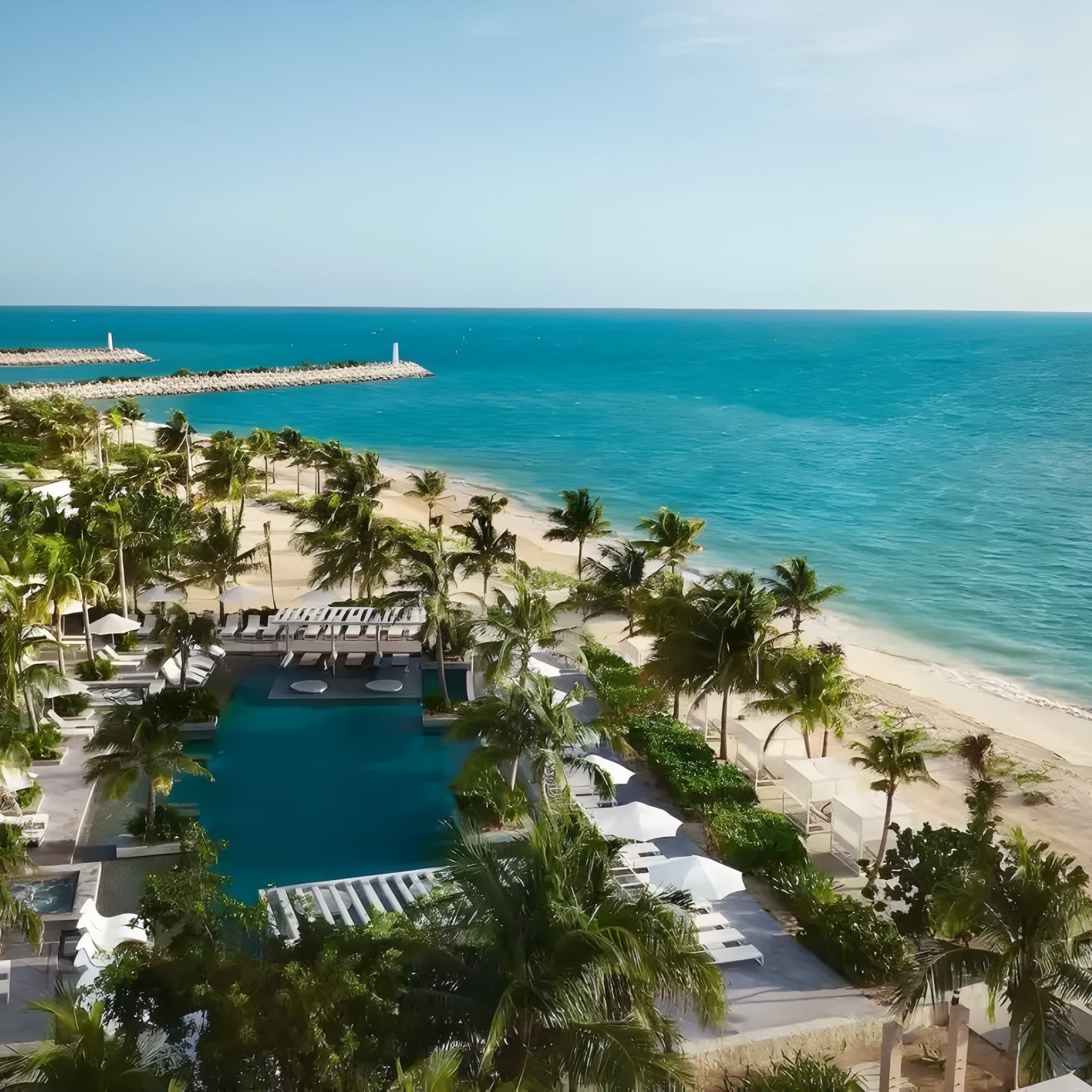 Aerial view of the Dreams Playa Mujeres destination wedding pool, palm trees, and ocean.